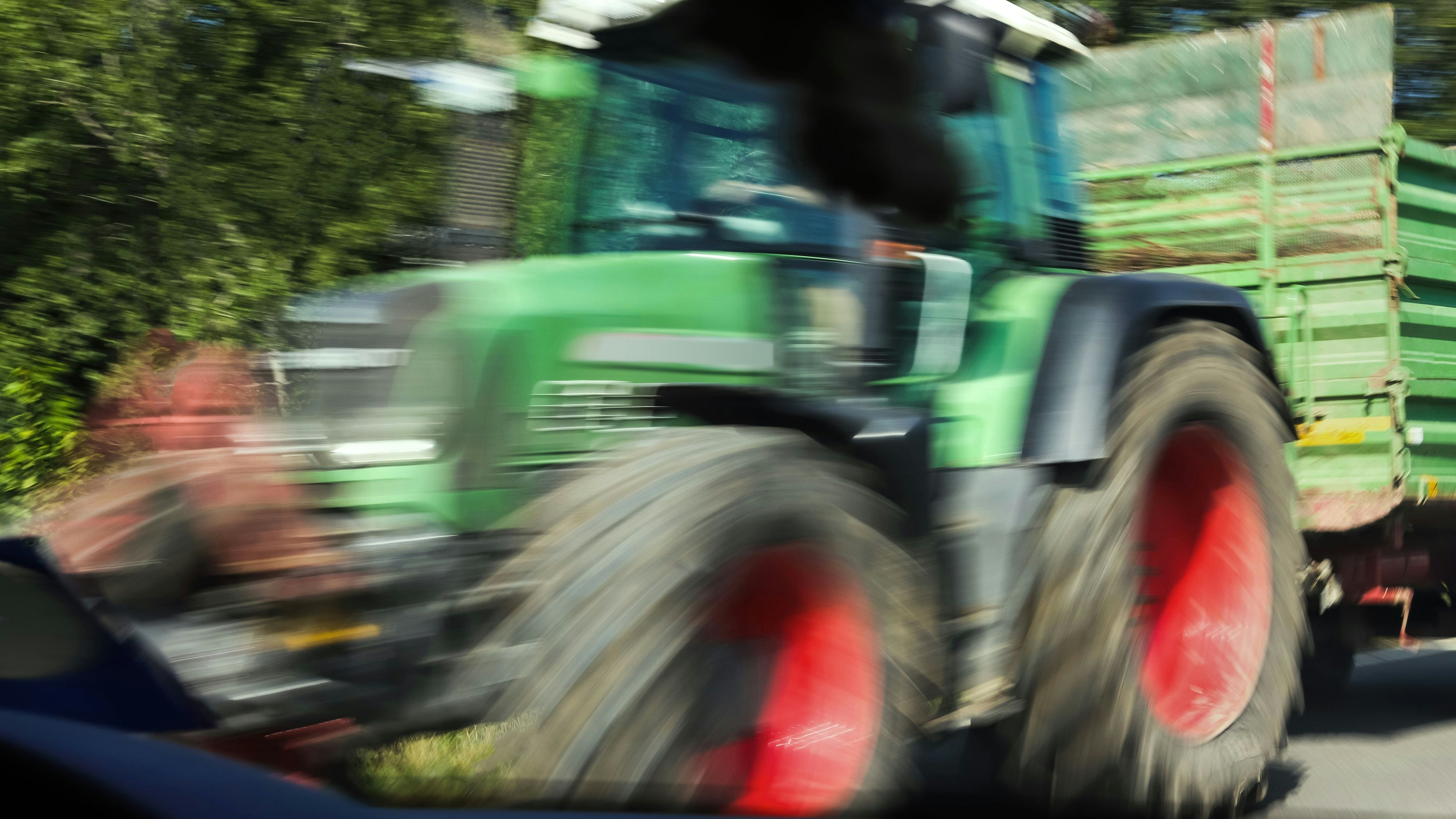 tractor speeding past a car