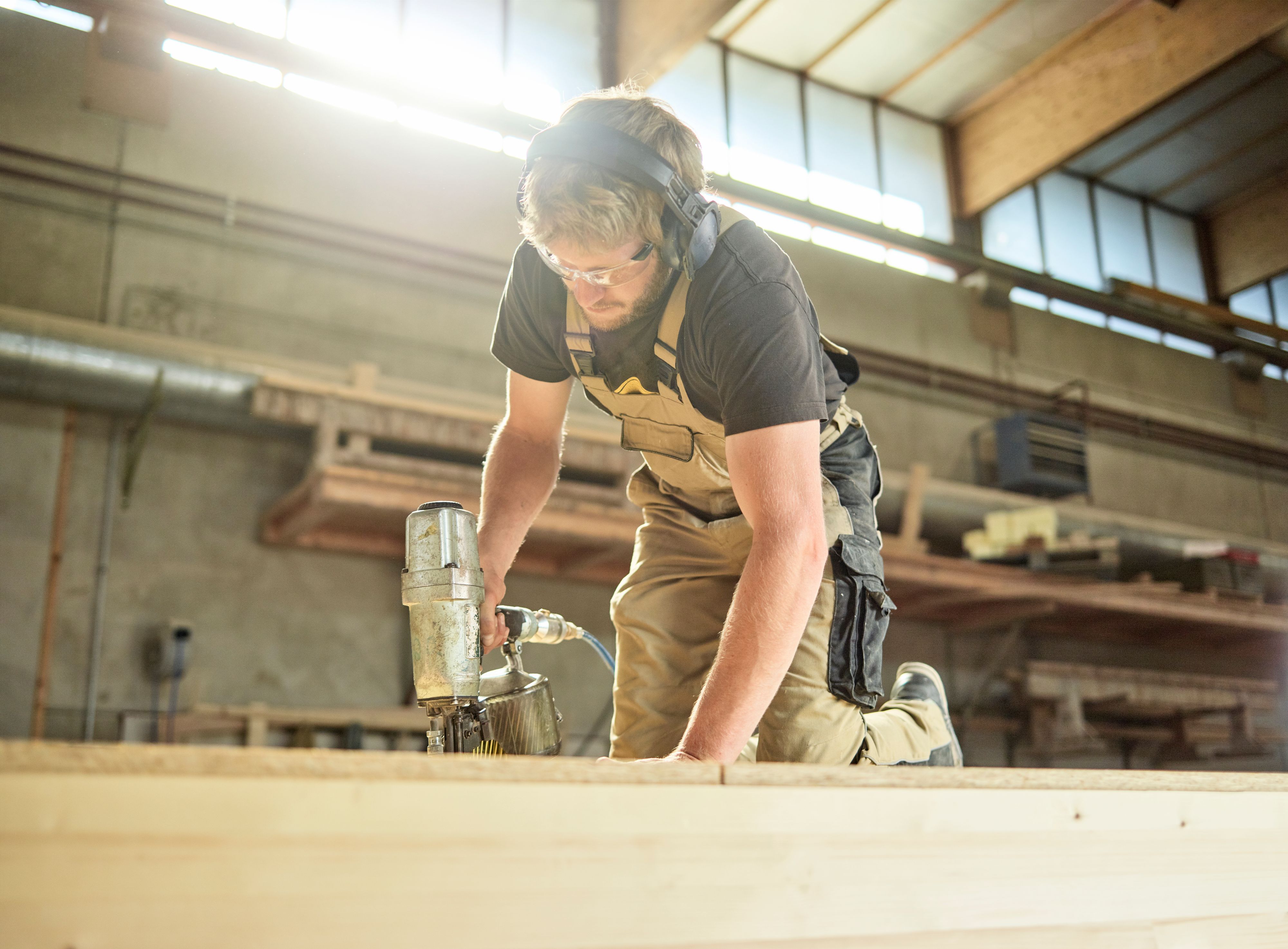 Download von www.picturedesk.com am 04.05.2022 (15:35).  Carpenter fixing medium-density fibreboard with air nailer - 20180306_PD16477 - Rechteinfo: Royalty Free (RF) Model Released