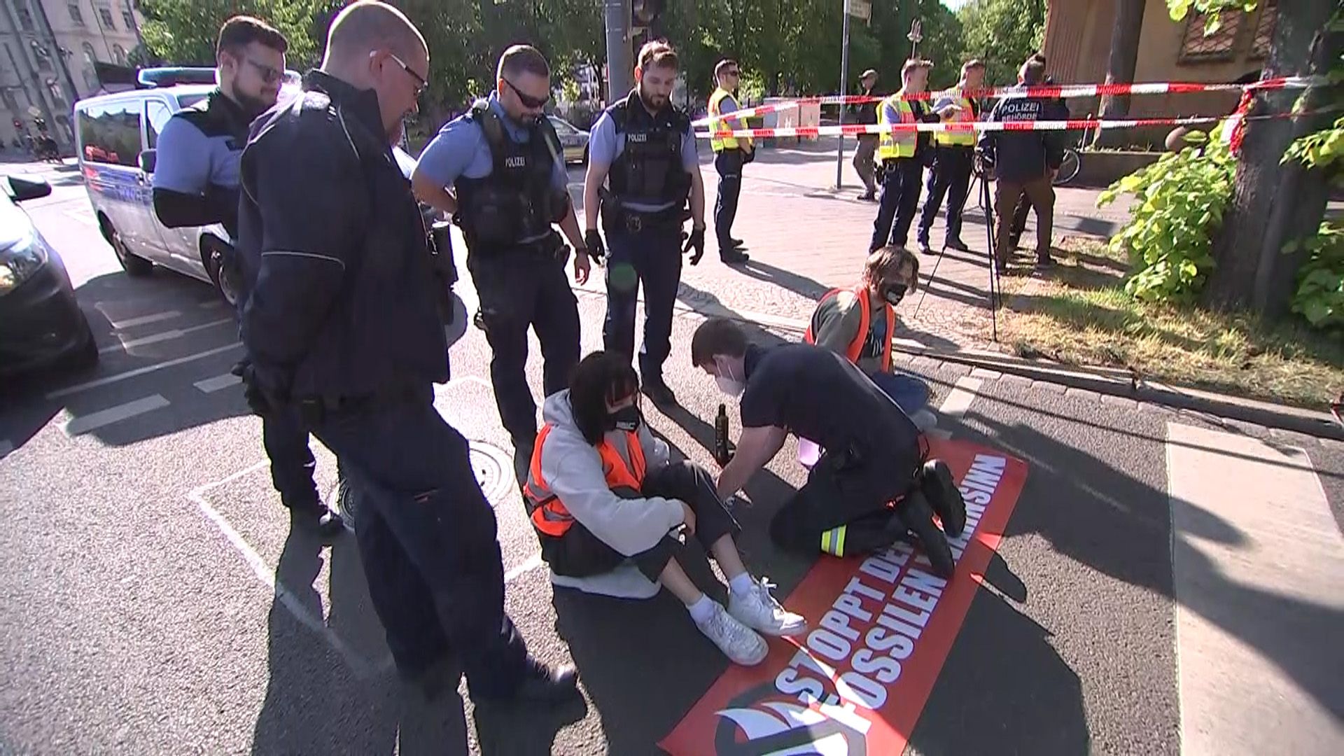Download von www.picturedesk.com am 09.05.2022 (15:49).  09 May 2022, Saxony, Leipzig: Environmental activists of the group "Last Generation" stuck themselves on the roadway and a policeman tried to remove the glue. Police task forces cordoned off the area and removed the protesters. Traffic was backed up over a wide area. Photo: Tobias Junghannß/TNN/dpa - 20220509_PD2450 - Rechteinfo: Rights Managed (RM)