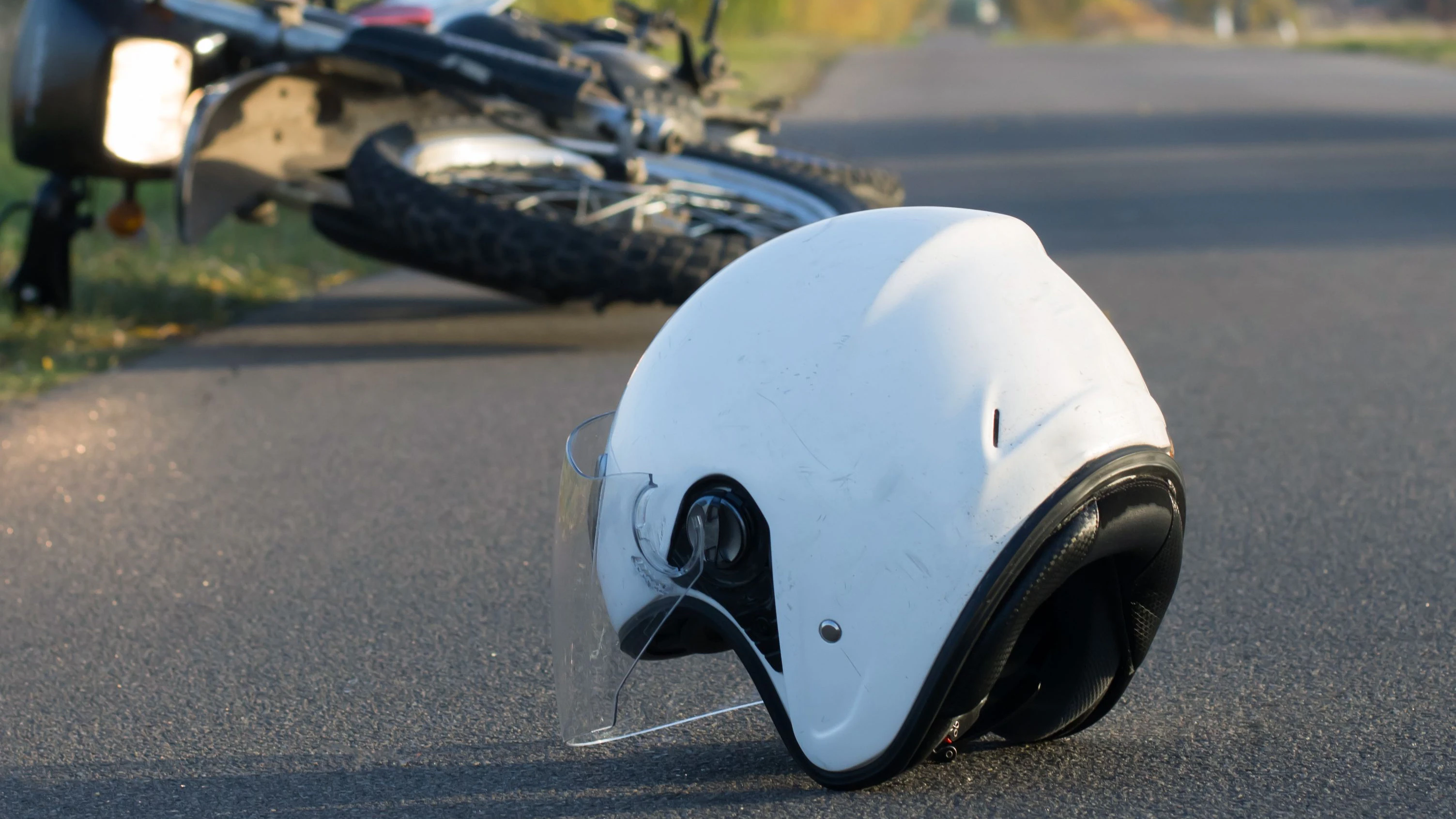 Photo of helmet and motorcycle on road, the concept of road accidents