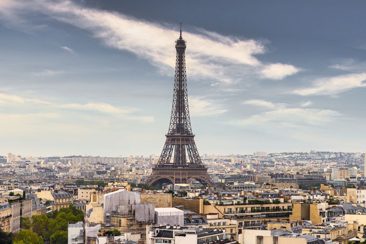 Eiffel Tower in Paris under blue summer skyscape. Aerial cityscape view over Paris with the iconic Eiffel Tower in the City Center at Champ de Mars, 7th Arrondissement, Paris, France, Europe