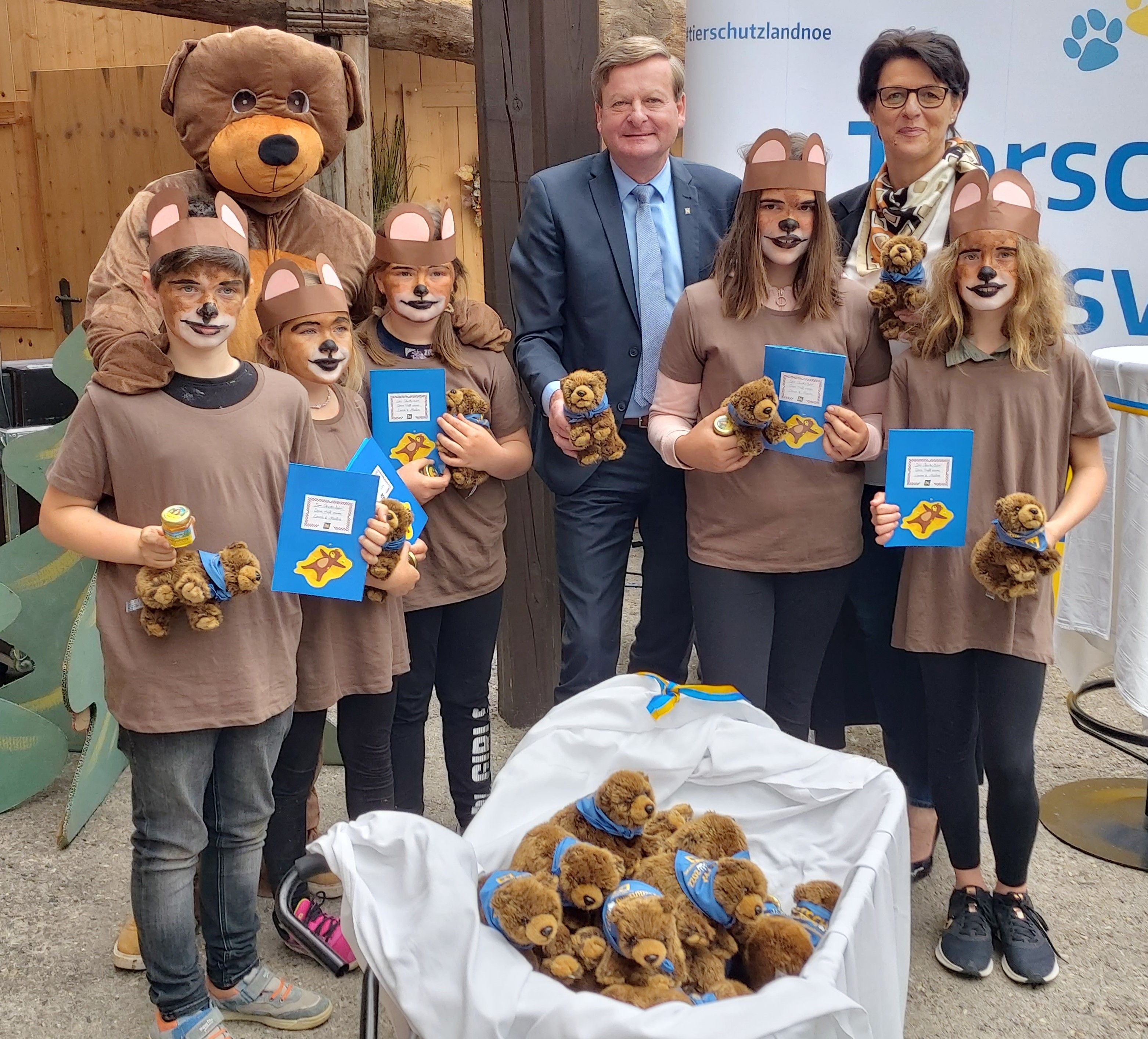 LR Waldhäusl übergibt Ötschi-Stofftiere, Honig und Malbücher. Am Foto: LR Waldhäusl, „Ötschi“ und Bürgermeisterin Renate Rakwetz mit den „Bärenkindern“ Leon Kaltenbrunner, Isabelle Utz, Hannah Latschbacher, Pia Steinhammer und Lea Kefer.