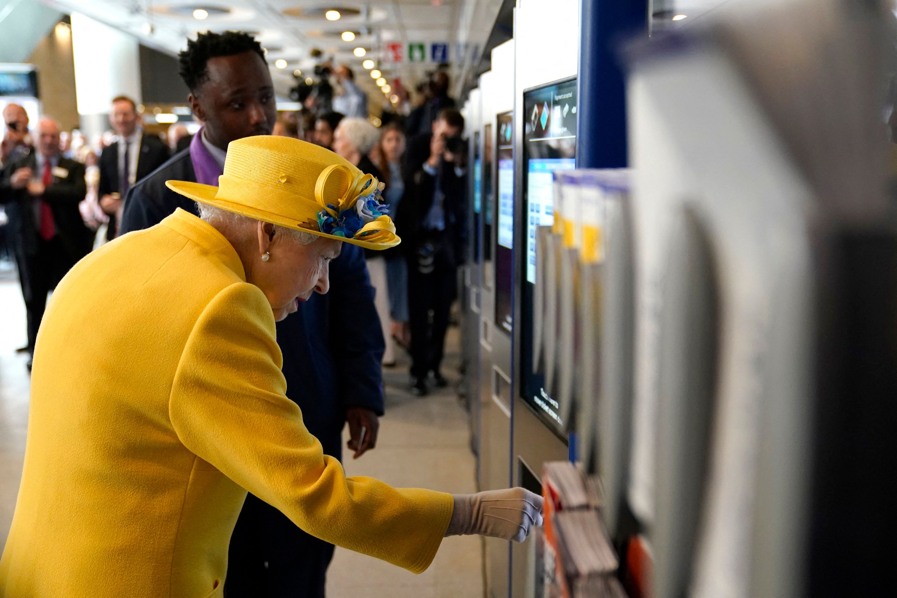 Die britische Königin nutzt einen Ticket-Automaten.