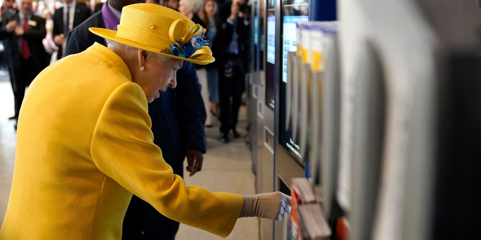 Die britische Königin nutzt einen Ticket-Automaten.