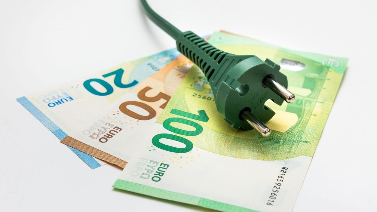 Green plug on euro banknotes - on white background Renewable energy and finance concept