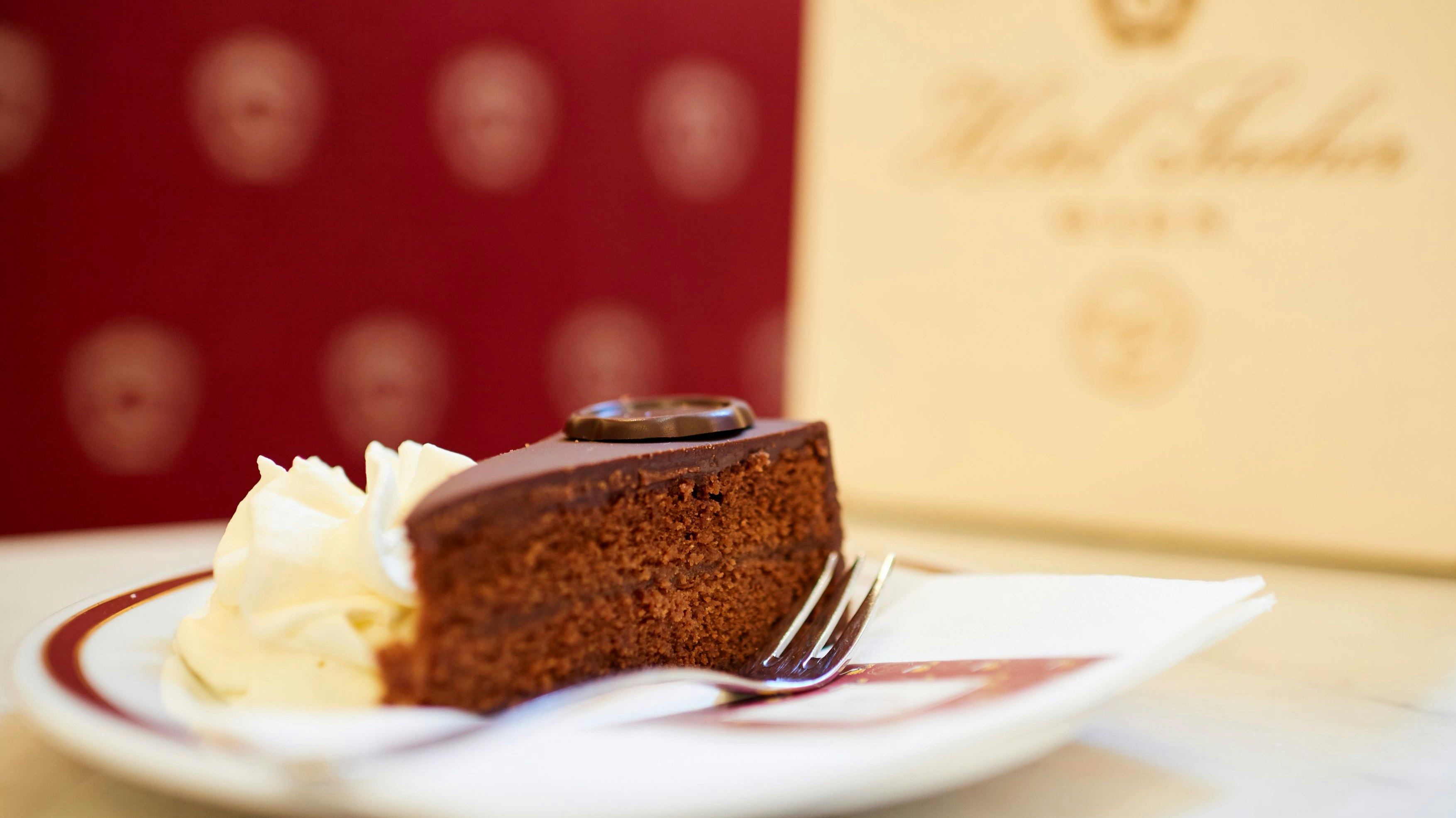 Download von www.picturedesk.com am 18.05.2022 (15:33).  Wien, Austria - August 22, 2017: Café Sacher, Sachertorte und Melange, im Hintergrund eine Torten-Verpackung. - 20170822_PD10274 - Rechteinfo: Rights Managed (RM) Nur fÃ¼r redaktionelle Nutzung!