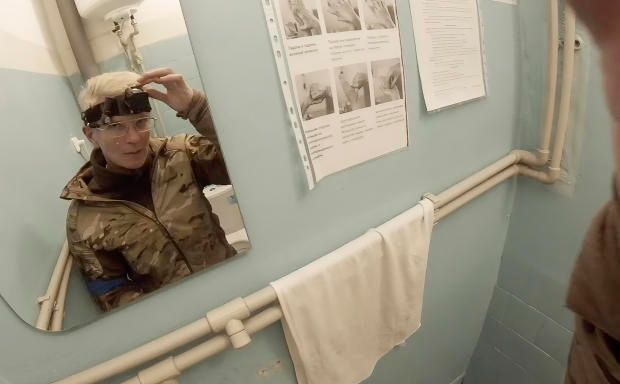 Yuliia Paievska, known as Taira, looks in the mirror and turns off her camera in Mariupol, Ukraine on Feb. 27, 2022. Using a body camera, she recorded her team's frantic efforts to bring people back from the brink of death. (Yuliia Paievska via AP)