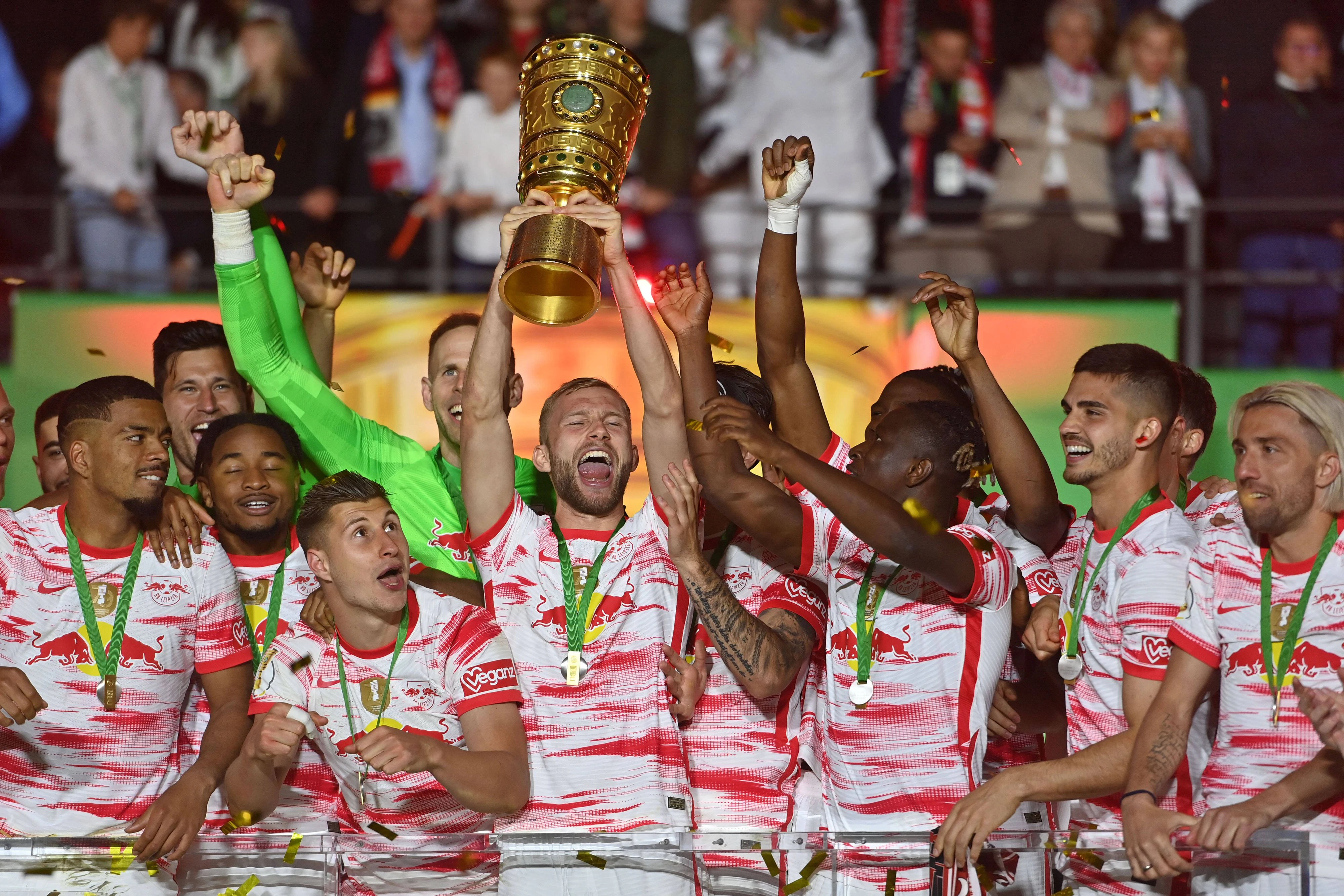 Konrad Laimer stemmt den DFB-Pokal in den Berliner Abendhimmel.