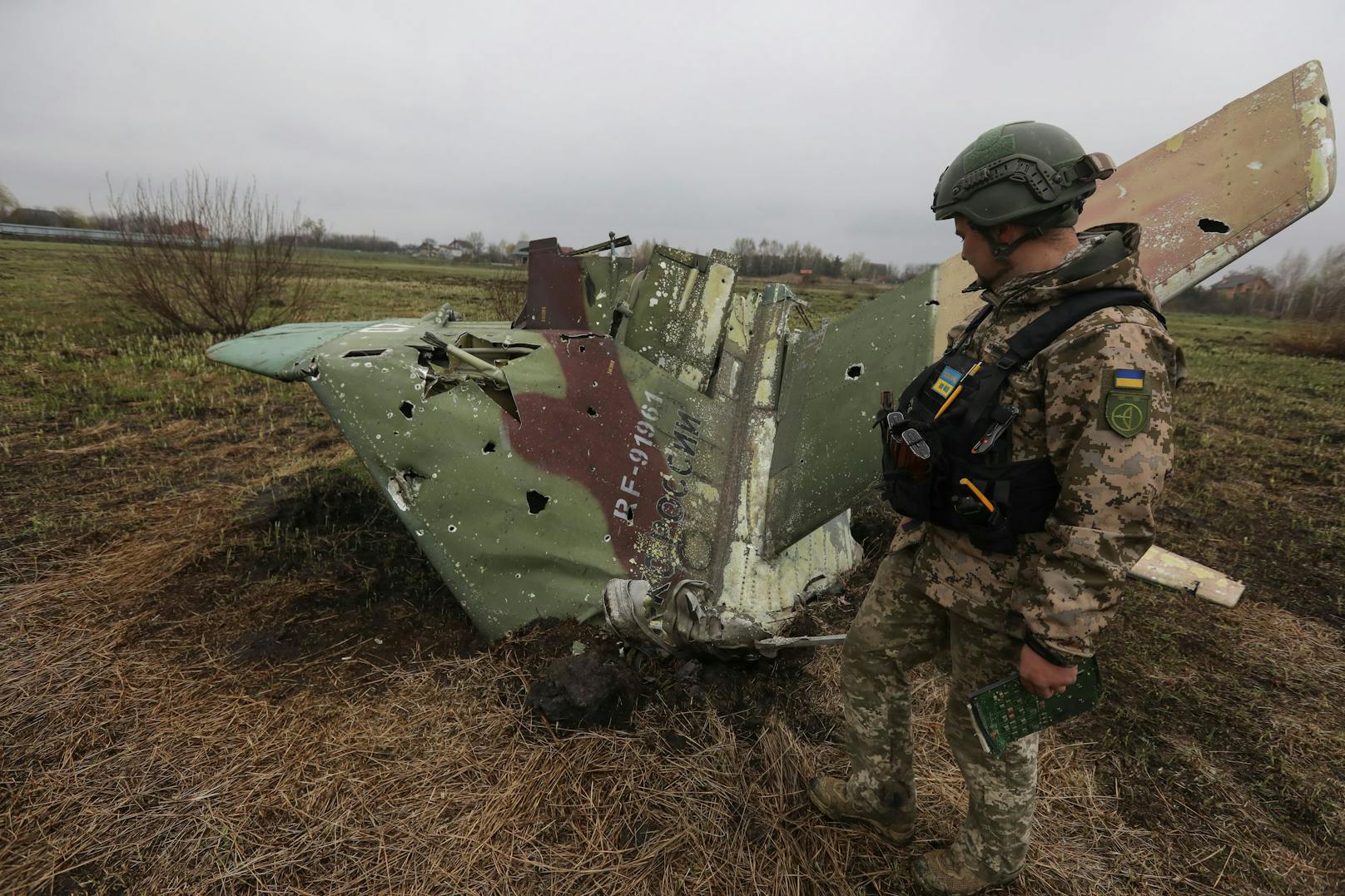 Ein Soldat inspiziert die Absturzstelle eines abgeschossenen russischen Sukhoi Su-25 Kampfjets in der Ukraine. (Symbolbild)