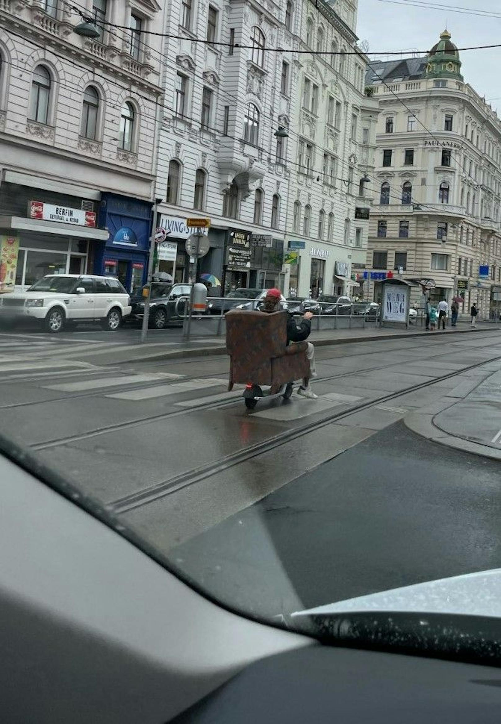Wiener transportiert Sofa mit E-Roller