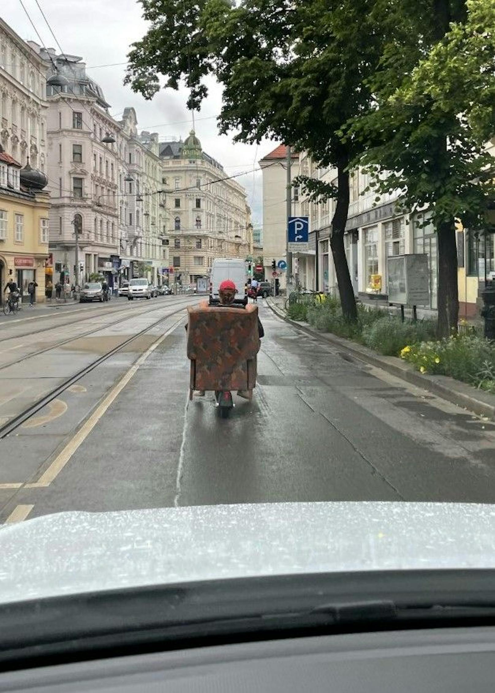 Wiener transportiert Sofa mit E-Roller