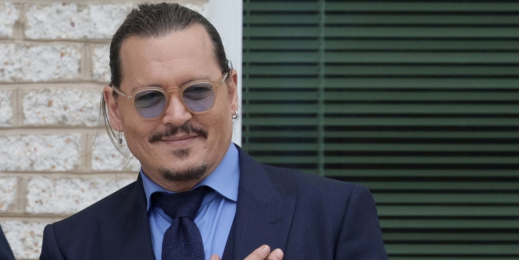 FILE PHOTO: Actor Johnny Depp smiles at fans following a break on the final day of his defamation trial against Amber Heard in Fairfax, Virginia, U.S., May 27, 2022. REUTERS/Evelyn Hockstein/File Photo