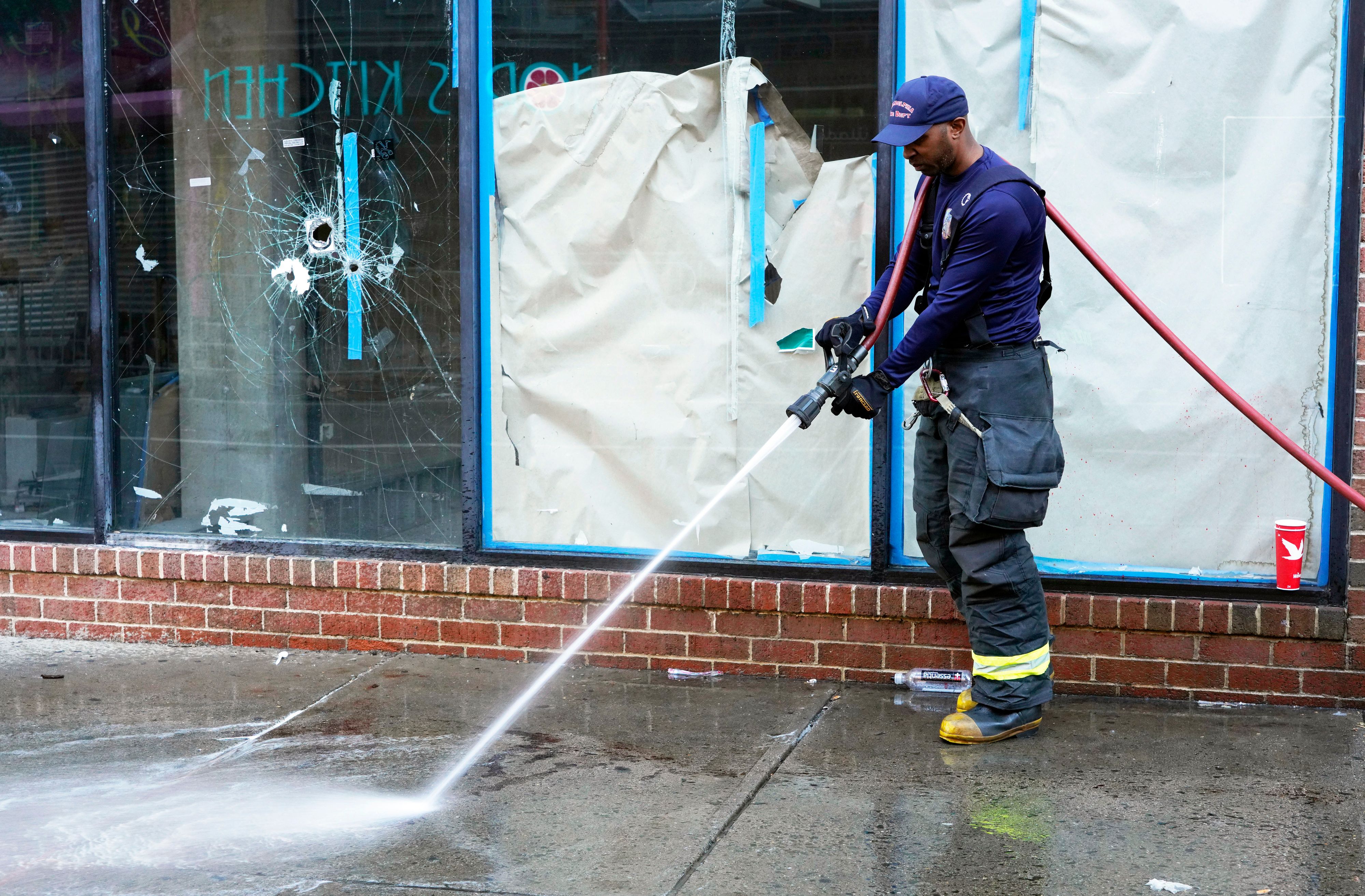Ein Feuerwehrmann beseitigt die Spuren der Nacht.