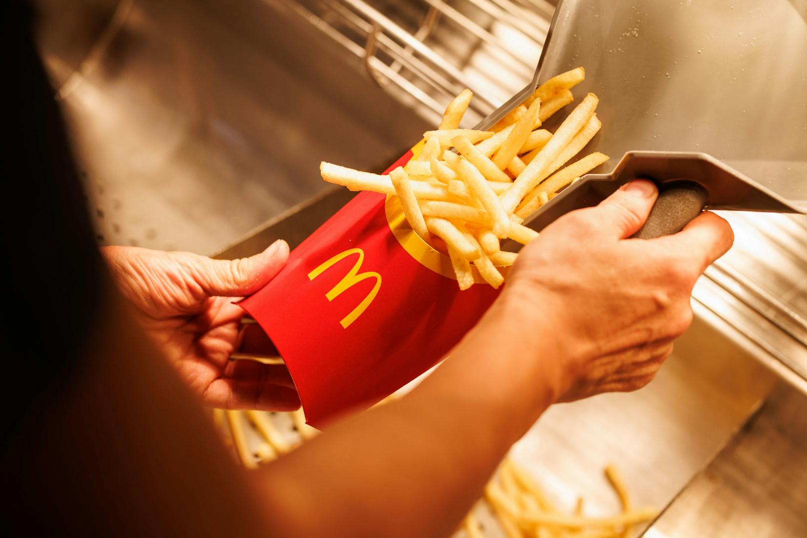 Ein McDonald's-Mitarbeiter beim Abfüllen einer Portion Pommes frites. (Symbolbild)
