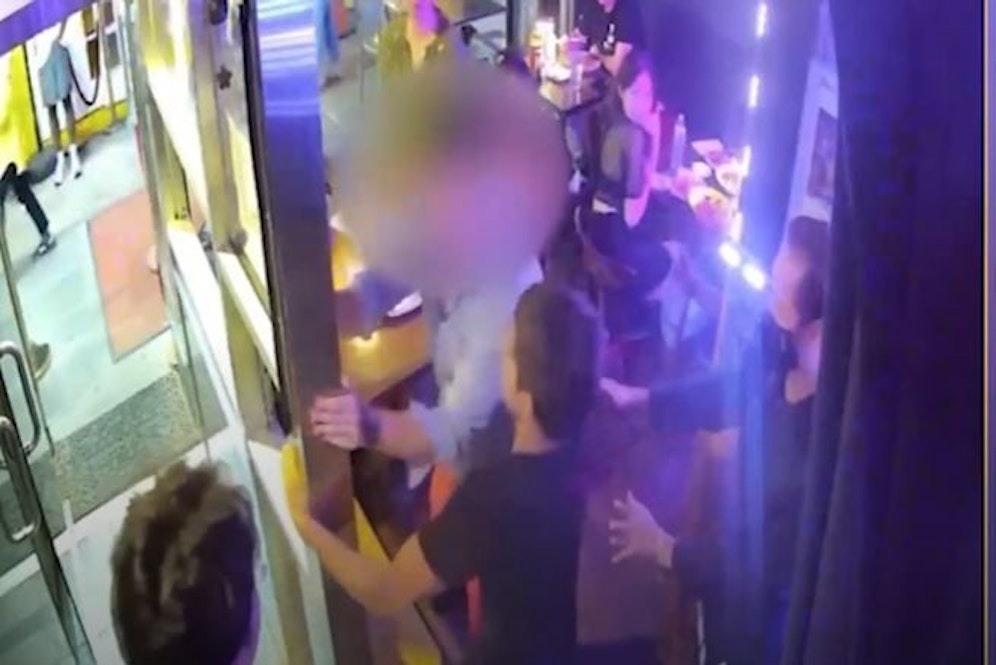 Der Bankdirektor (verpixelt) musste von einigen Angestellten zurückgehalten werden. 