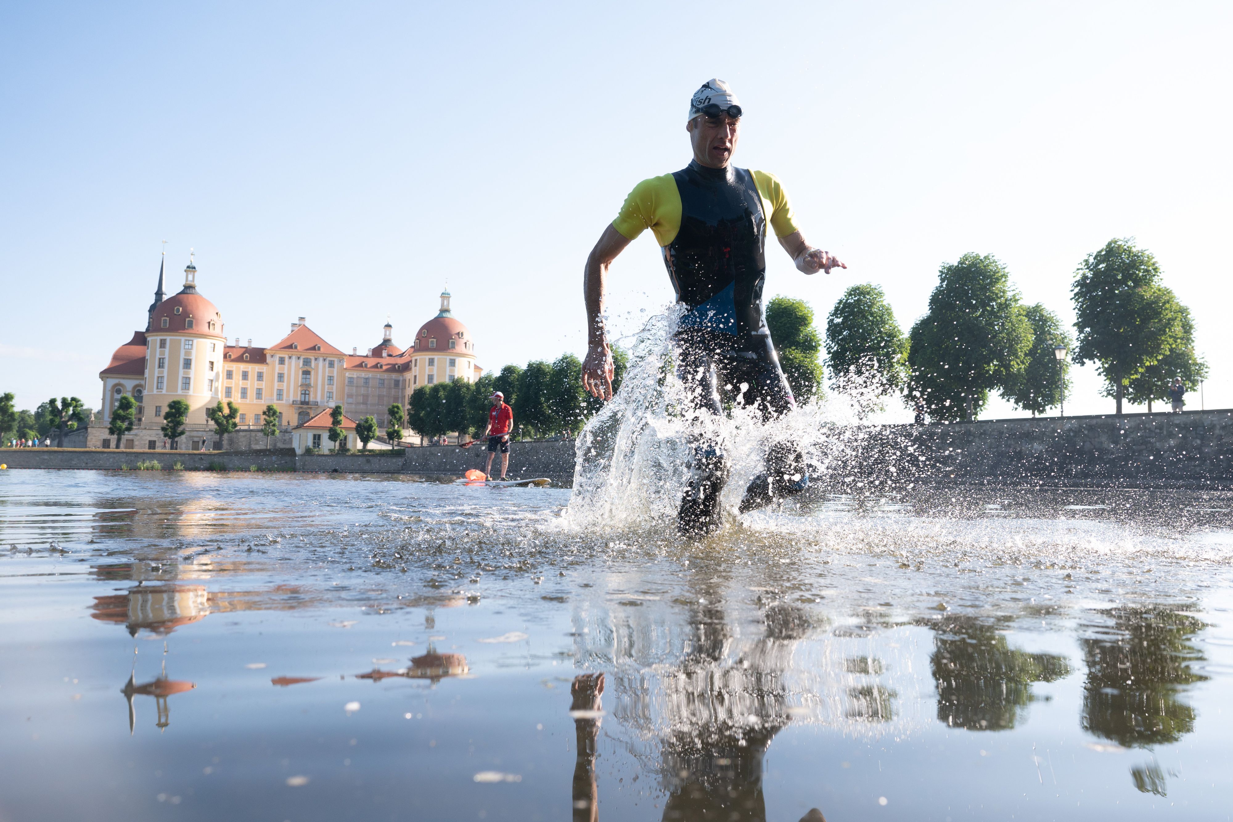 Download von www.picturedesk.com am 14.06.2022 (11:25).  11 June 2022, Saxony, Moritzburg: A participant of the Moritzburg Castle Triathlon runs out of the castle pond against the backdrop of Moritzburg Castle. After two years of corona-related cancellations, the triathlon celebrates its 20th anniversary. Photo: Sebastian Kahnert/dpa/ZB - 20220611_PD0780 - Rechteinfo: Rights Managed (RM)