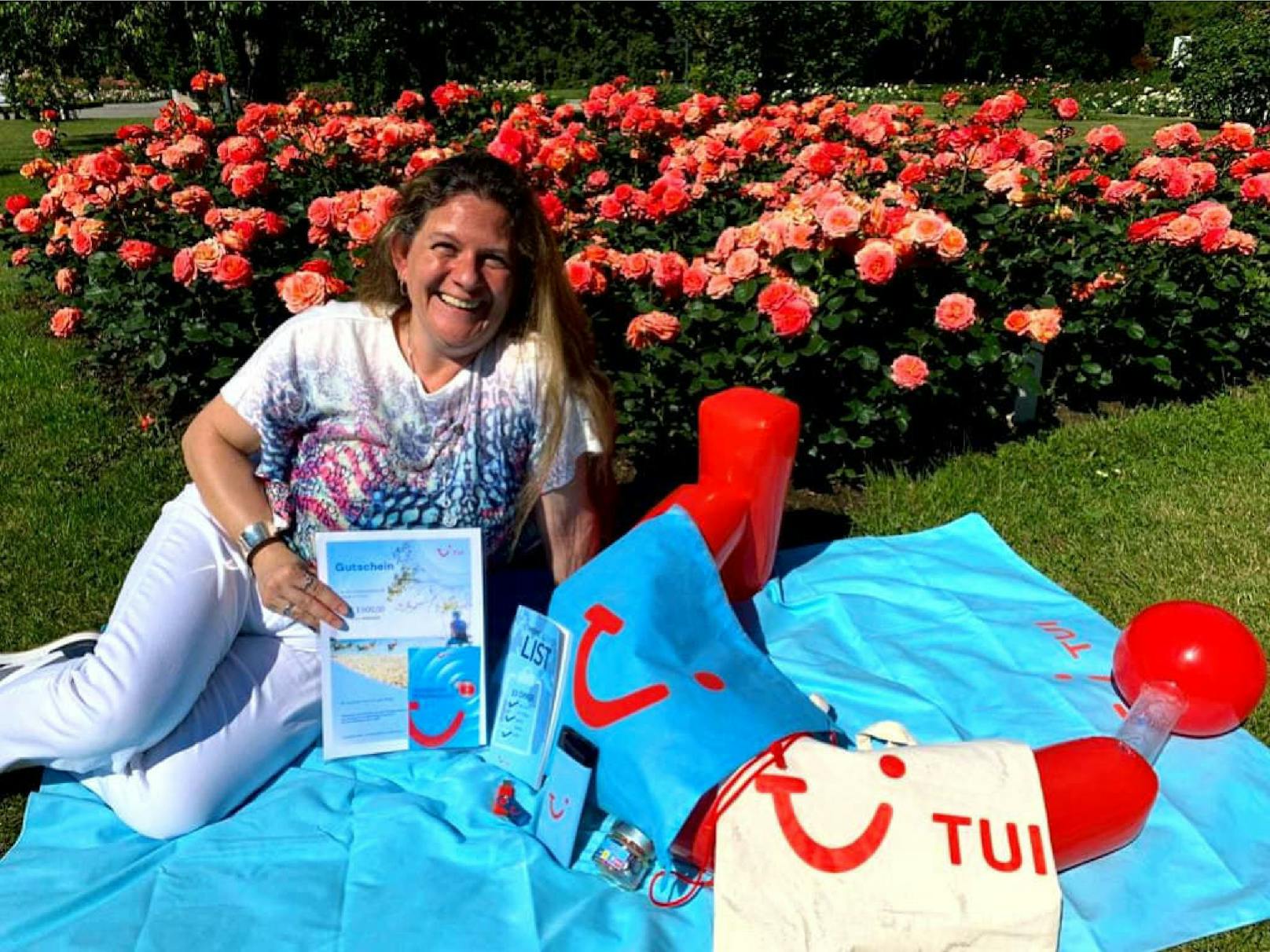 Reisegutschein-Gewinnerin Doris K. aus Bad Vöslau mit ihrem € 3.000,- Reisegutschein von TUI und dem Inhalt des TUI-Goodiebags.