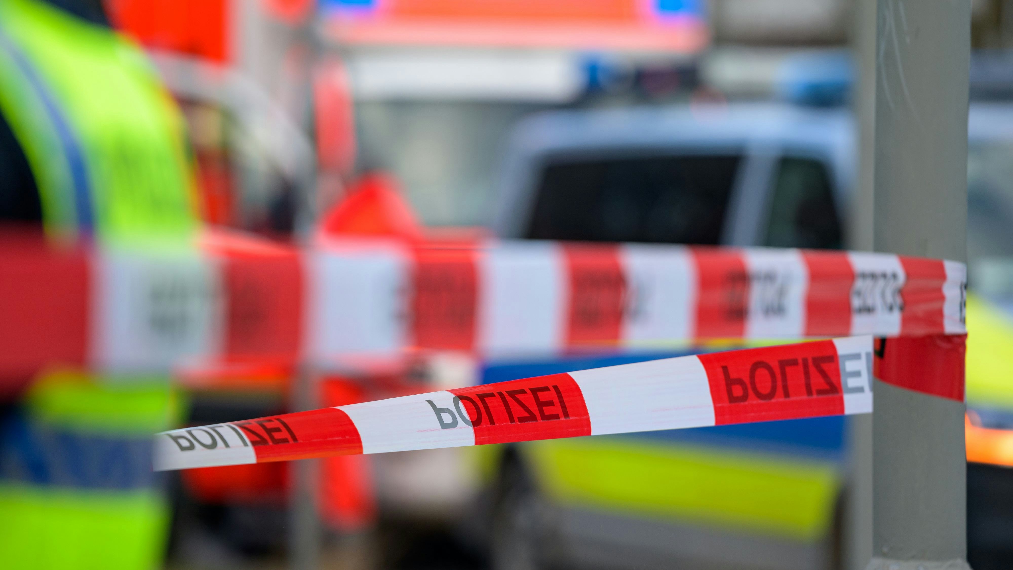 Download von www.picturedesk.com am 22.06.2022 (14:51).  26 February 2022, Hamburg: Emergency vehicles of the fire department and police stand behind the scene, which is cordoned off with flutter tape. A man was killed in an accident at a construction site in Hamburg-Lokstedt when the jib of a construction crane came loose and fell onto a house under construction. Photo: Jonas Walzberg/dpa - 20220226_PD8405 - Rechteinfo: Rights Managed (RM)