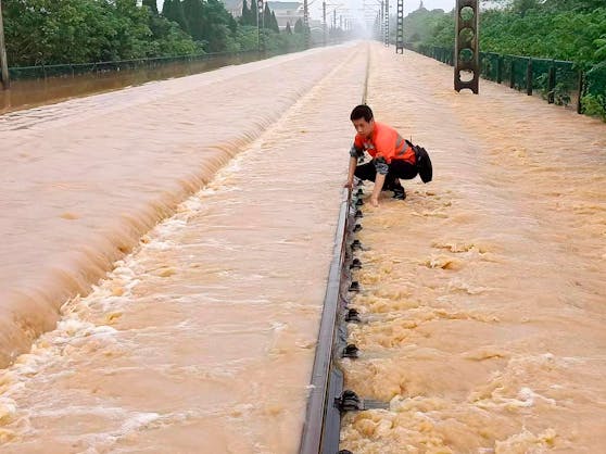 Ein Arbeiter kontrolliert einen Abschnitt einer überfluteten Eisenbahn in Shangrao in der zentralchinesischen Provinz Jiangxi.