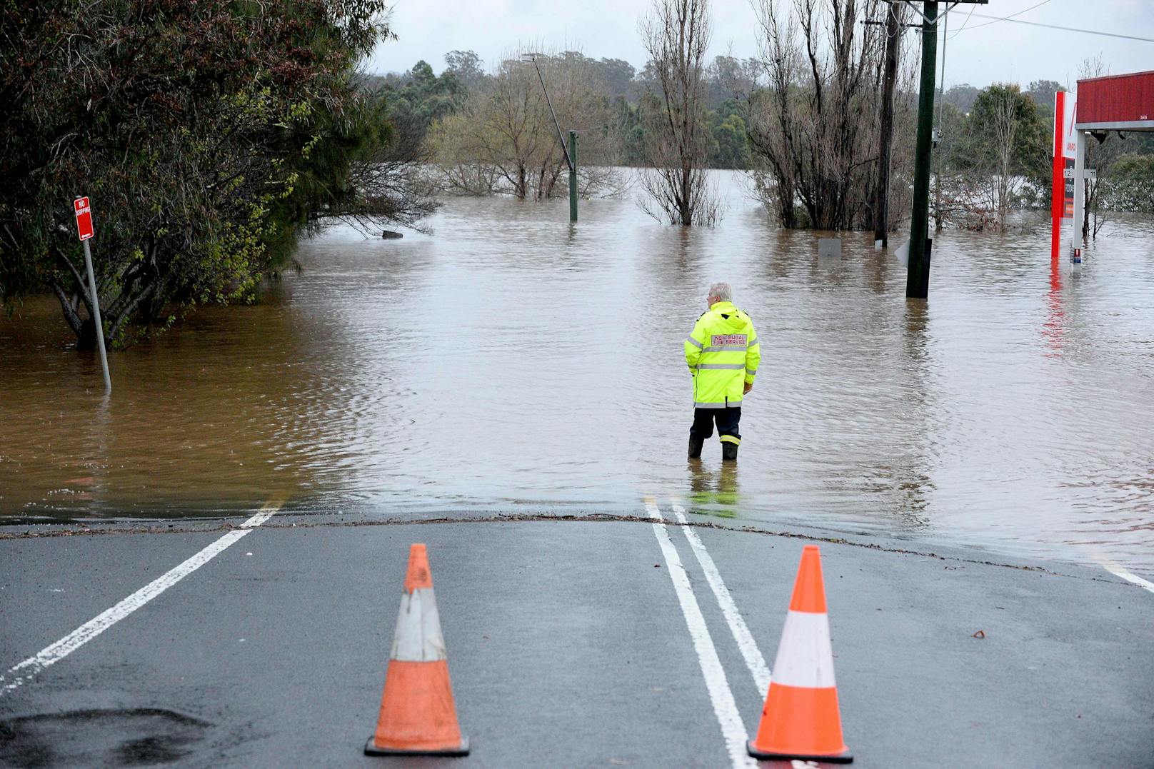 Ein Rettungssanitäter untersucht am 3. Juli 2022 ein durch sintflutartigen Regen überschwemmtes Gebiet im Vorort Camden von Sydney.