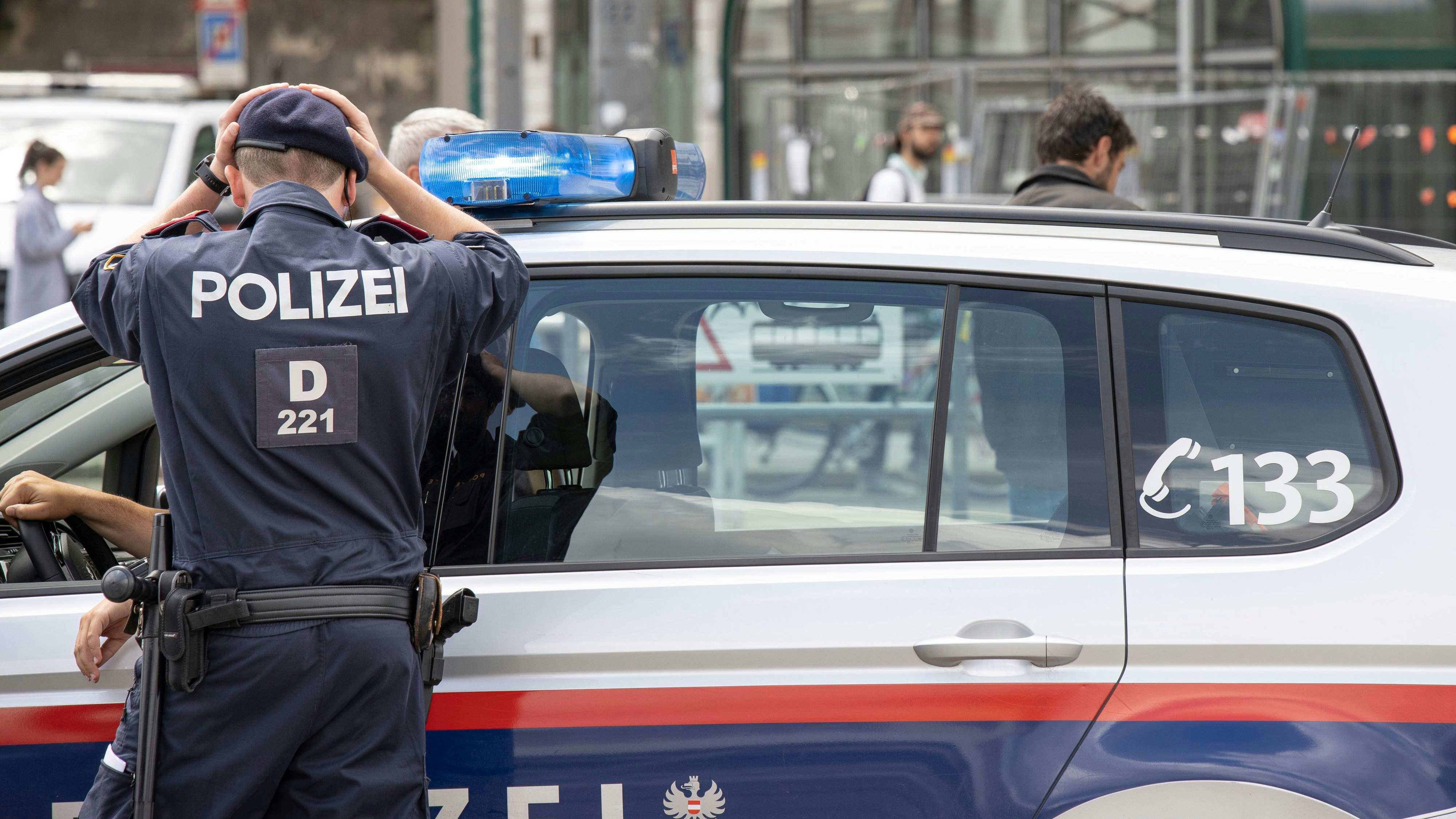 Polizisten und Polizeifahrzeuge im Einsatz in Wien. Symbolbild