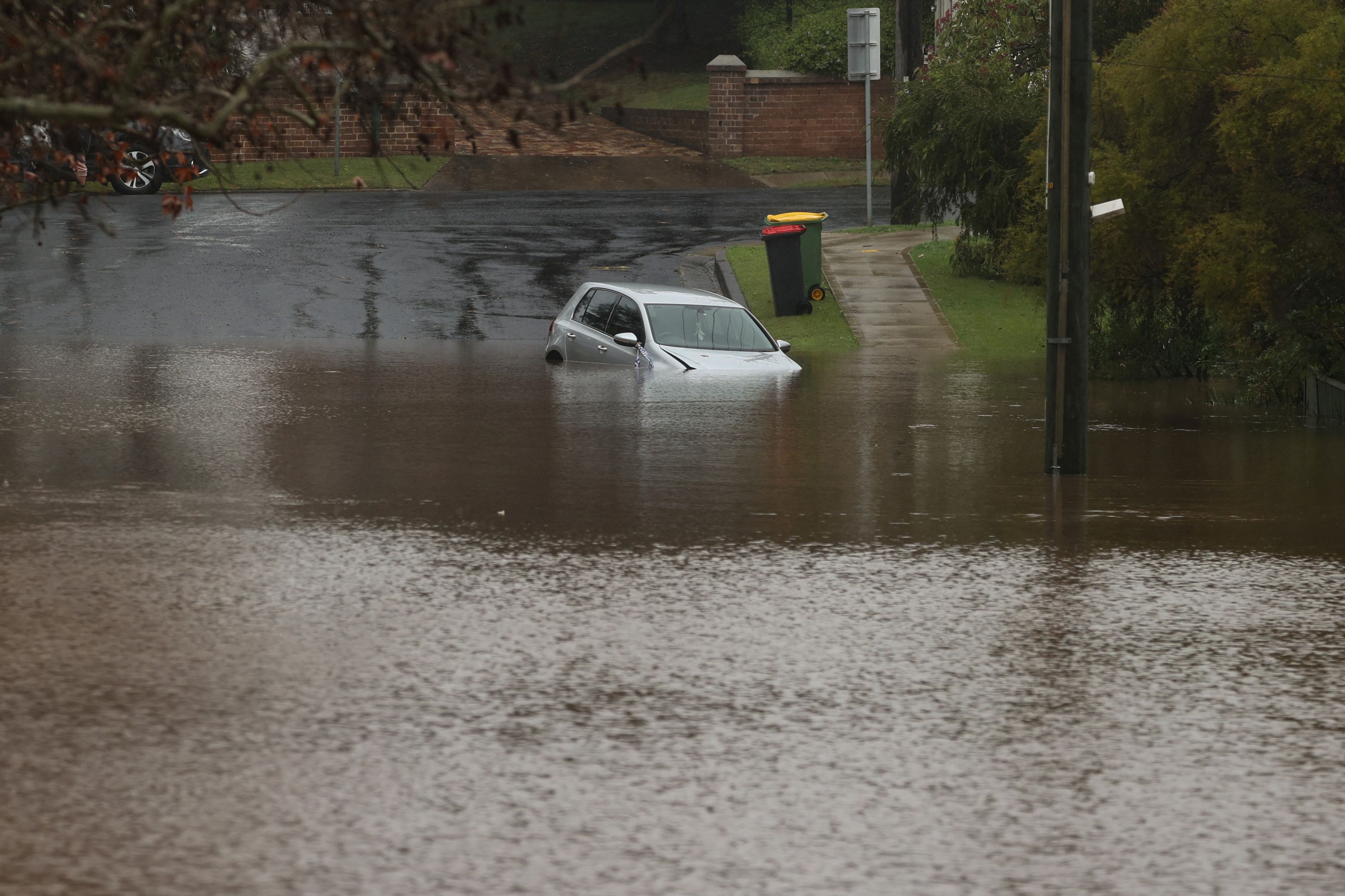 A vehicle is submerged by floodwaters in a residential area following heavy rains in the Windsor suburb of Sydney, Australia, July 5, 2022.  REUTERS/Loren Elliott