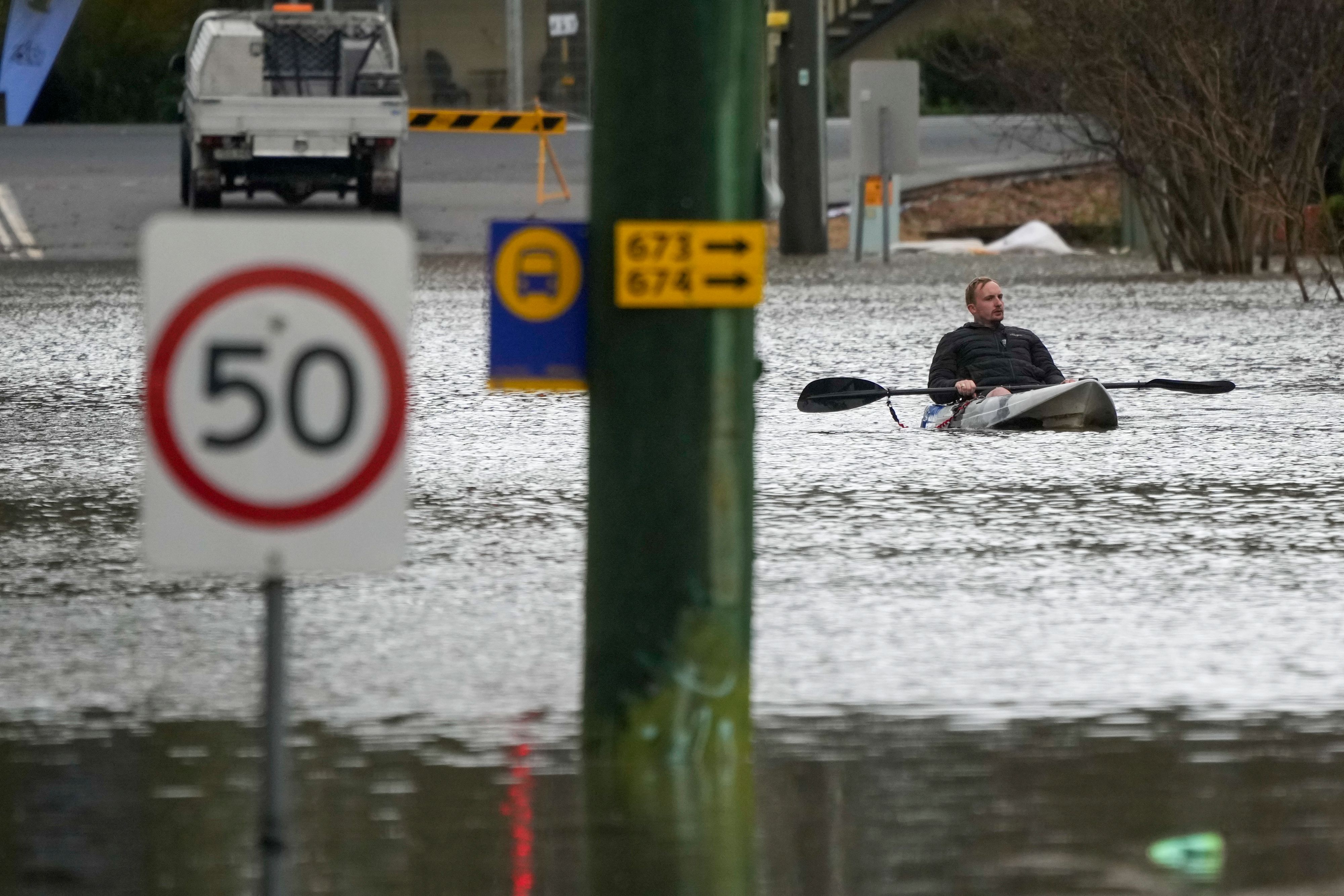 Download von www.picturedesk.com am 05.07.2022 (09:22).  A man paddles his kayak through a flooded street at Windsor on the outskirts of Sydney, Australia, Tuesday, July 5, 2022. Hundreds of homes have been inundated in and around Australia's largest city in a flood emergency that was impacting 50,000 people, officials said Tuesday. (AP Photo/Mark Baker) - 20220705_PD0574 - Rechteinfo: Rights Managed (RM)