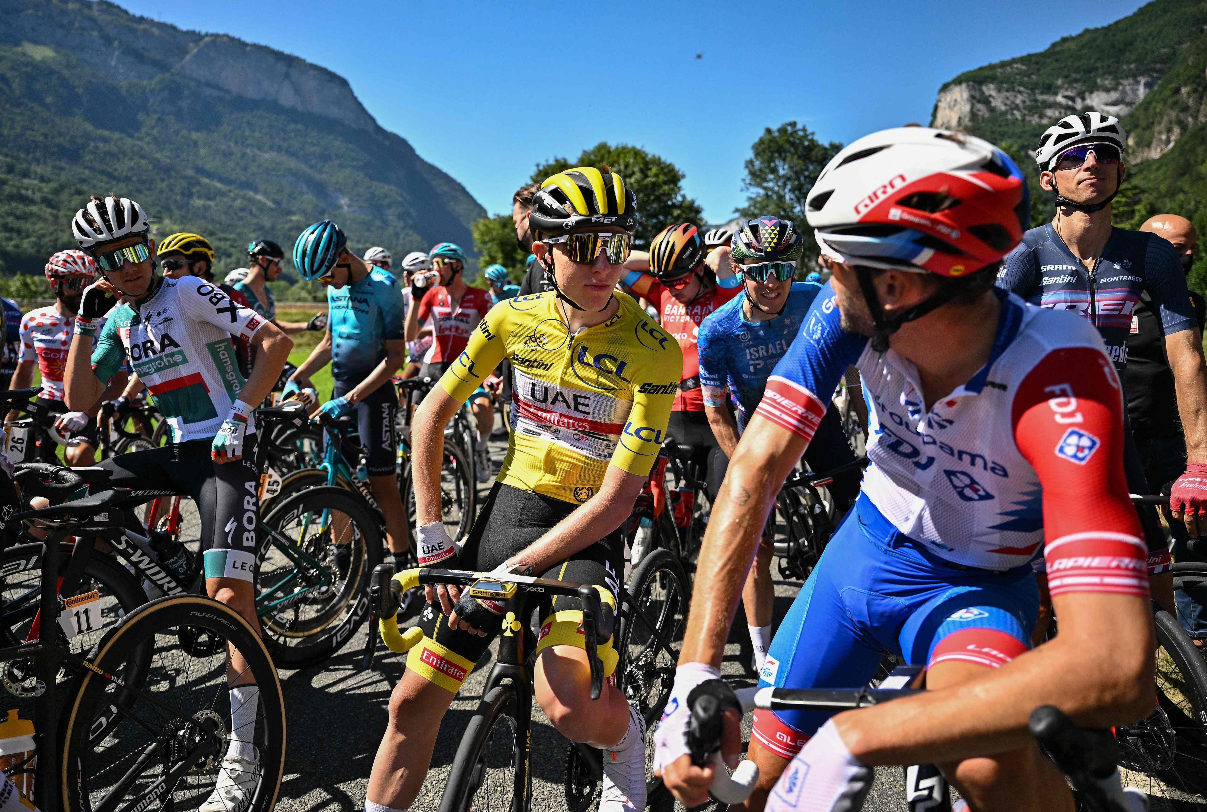 Tour-Leader Pogacar und seine Kontrahenten unterhalten sich während der unfreiwilligen Pause.