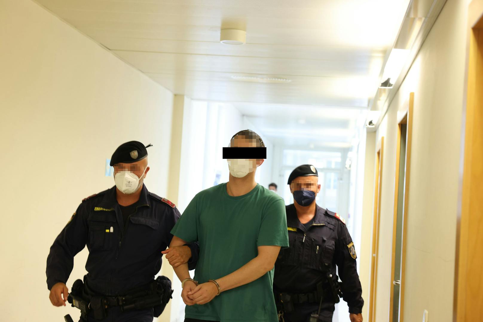Der 34-Jährige am Weg in den Gerichtssaal, flankiert von zwei Beamten