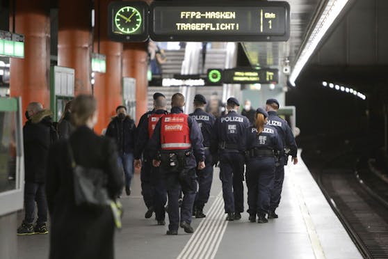 Polizisten und Sicherheitspersonal der Wiener Linien in der U4-Station Karlsplatz. Die Überkopf-Tafeln weisen auf die Maskenpflicht hin. Archivbild, Februar 2022. 