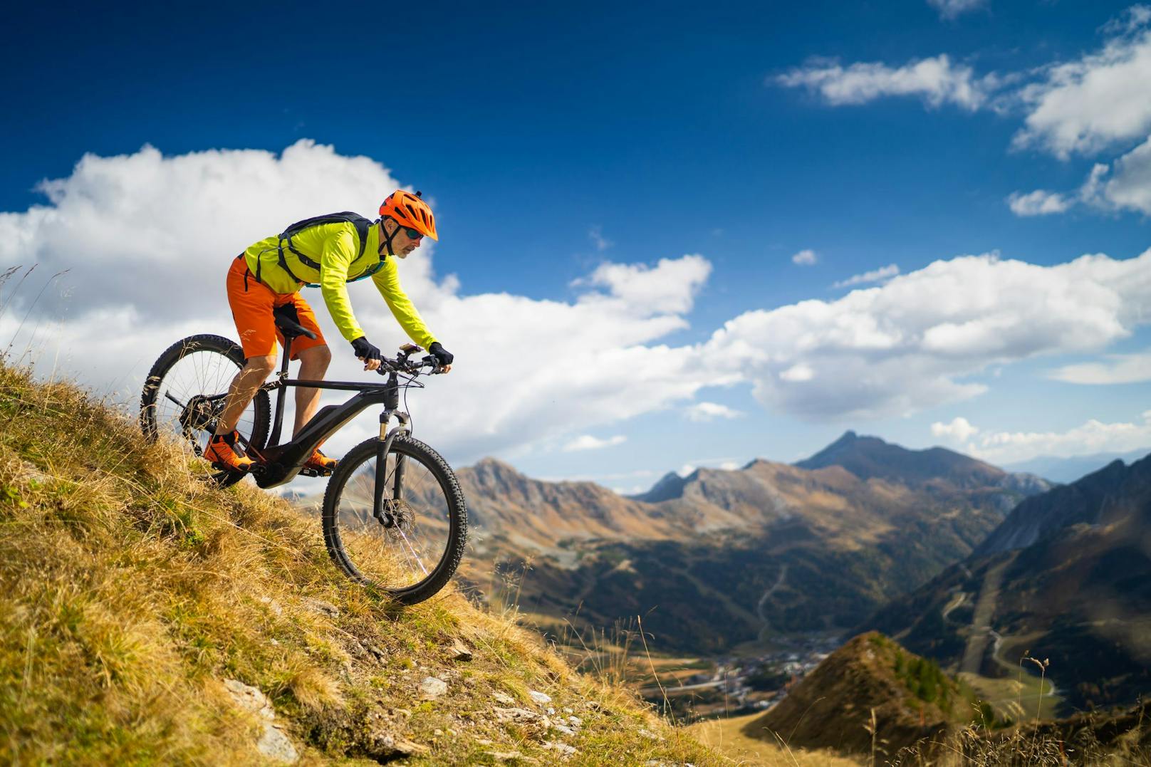 Ein E-Bike-Fahrer rauscht von einem Berg ins Tal. Symbolbild.