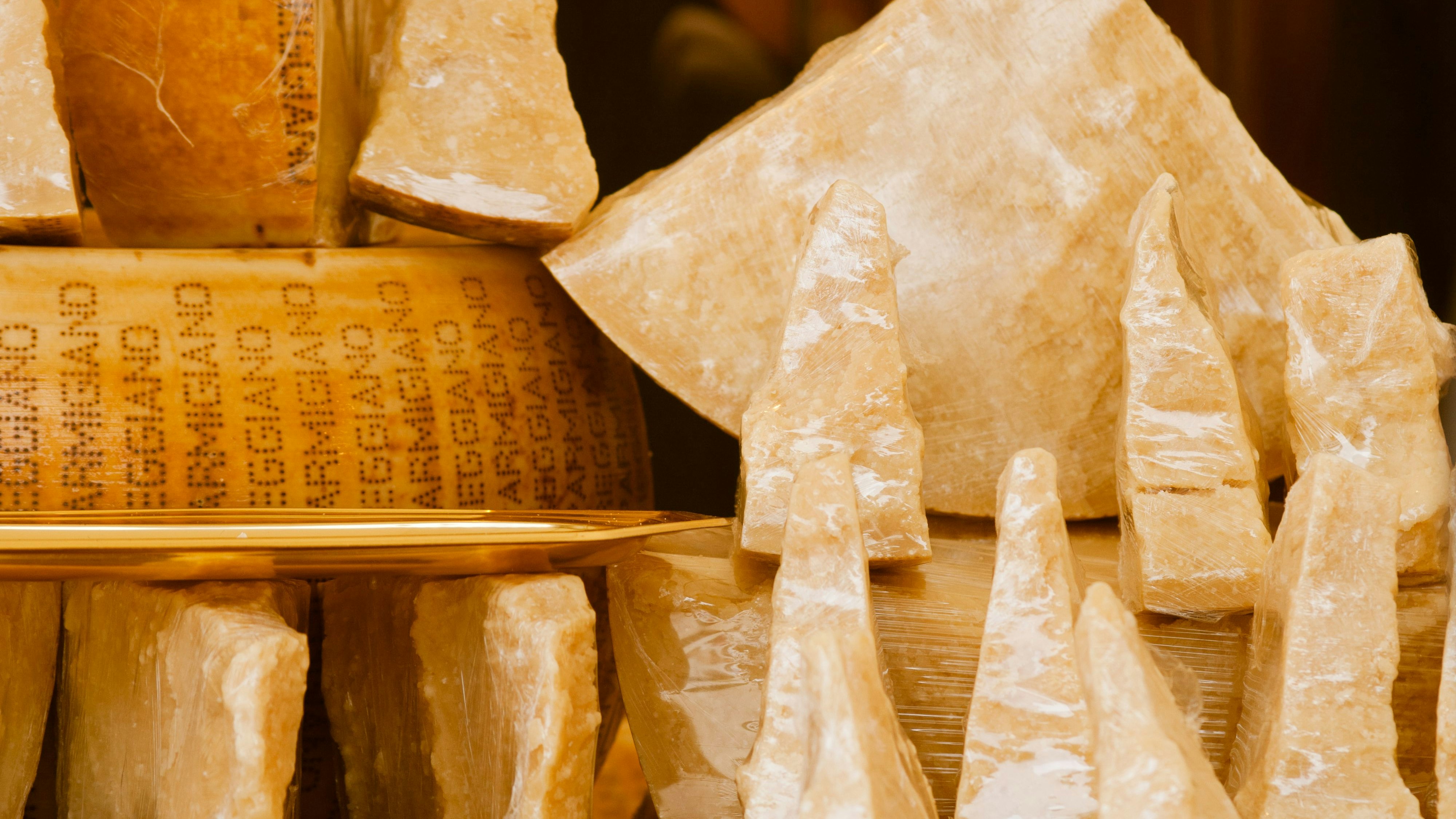 Nice, France - June 1, 2012: Hard parmesan heads and chunks on market. Cheese showcase.