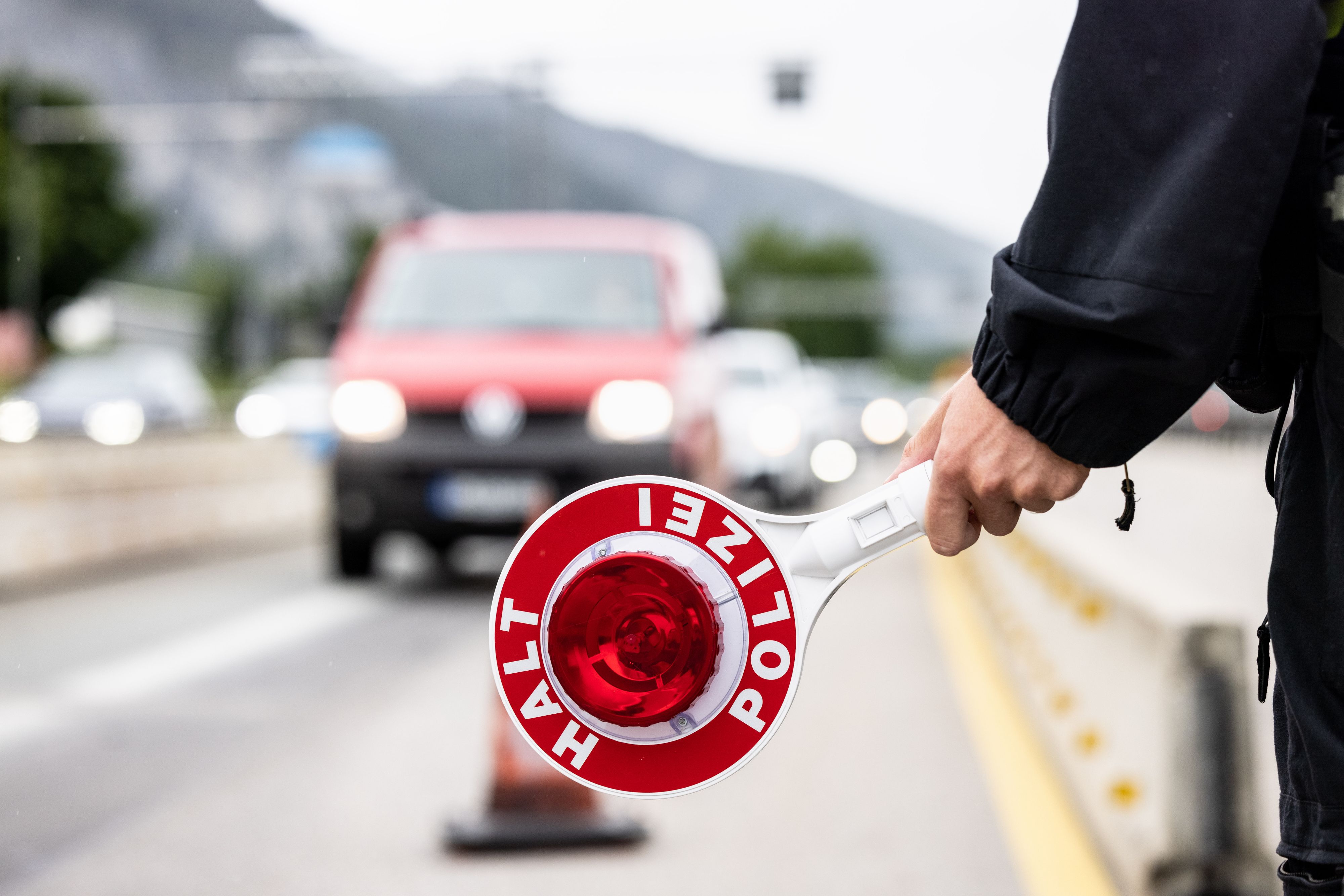 Download von www.picturedesk.com am 26.07.2022 (12:13).  FILED - 01 August 2021, Bavaria, Kiefersfelden: A German federal police officer holds a ladle with the inscription "Halt Polizei" at a checkpoint on the border with Austria on Autobahn 93 near Kiefersfelden. Photo: Matthias Balk/dpa - 20210801_PD32268 - Rechteinfo: Rights Managed (RM)