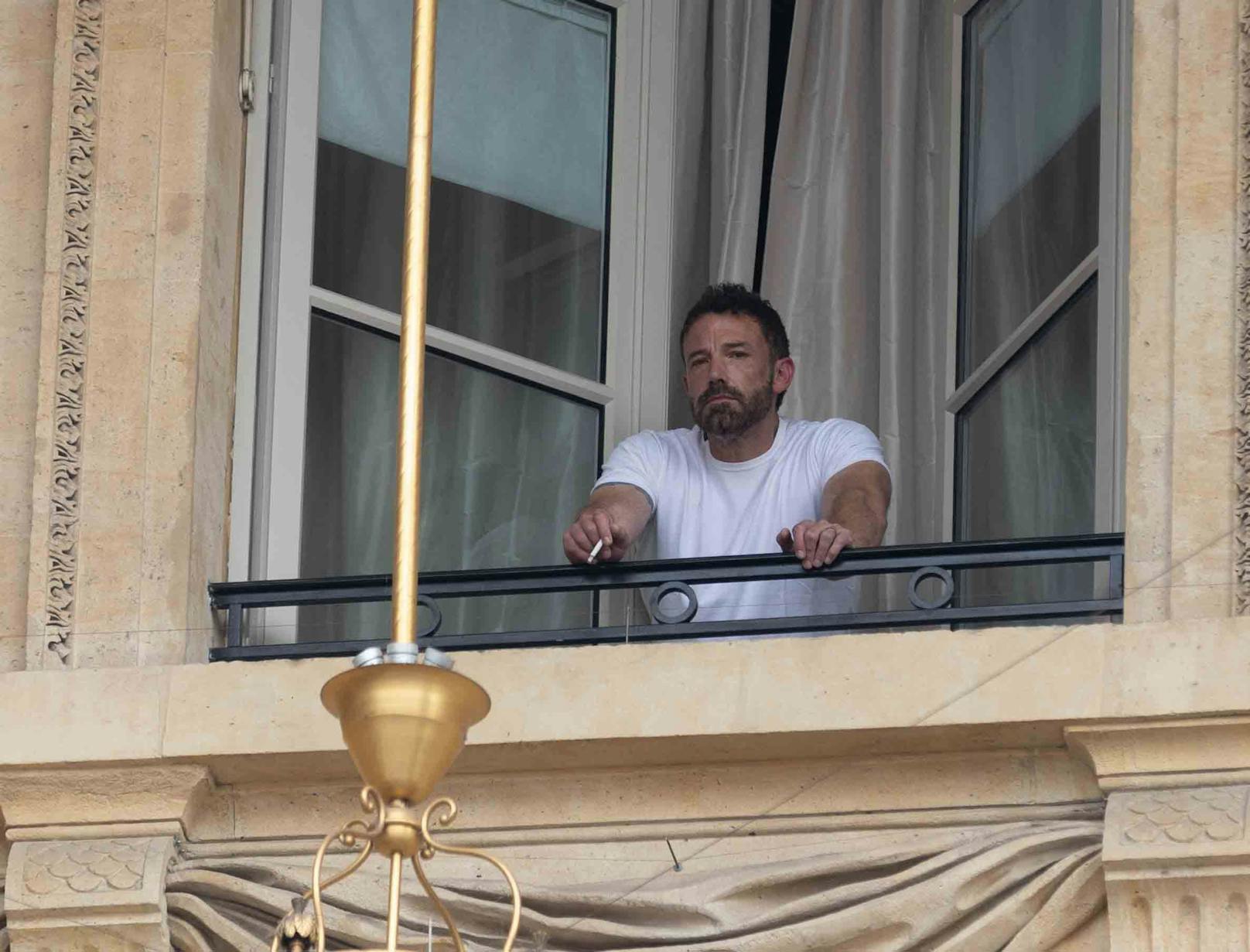 Der Star raucht aus dem Fenster seines Pariser Hotel.