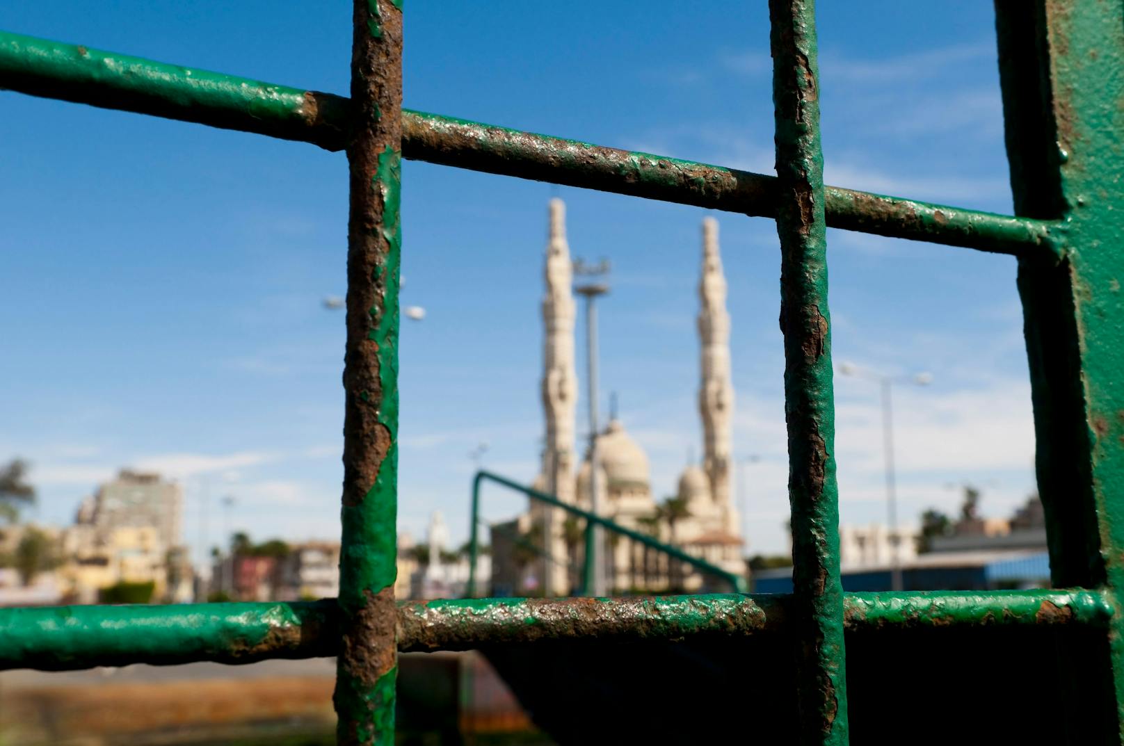 The view of a mosque through a rusting iron cage. Location: Port Said, Egypt
