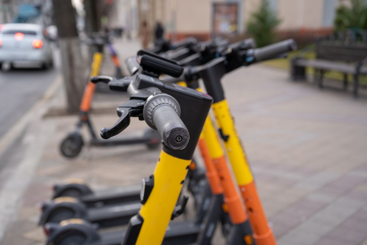 Electric urban transportation. The row of electric readies to ride scooter bikes with accumulators in the center of a city on the pavement stone.
