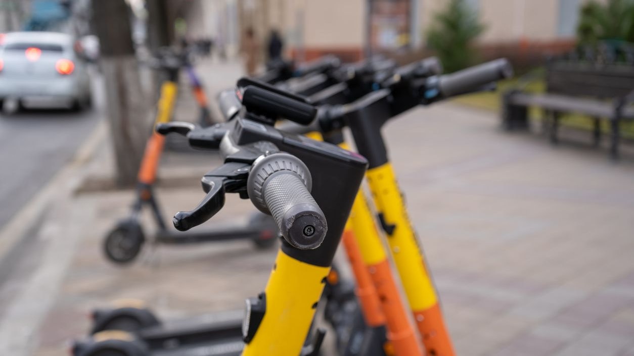Electric urban transportation. The row of electric readies to ride scooter bikes with accumulators in the center of a city on the pavement stone.