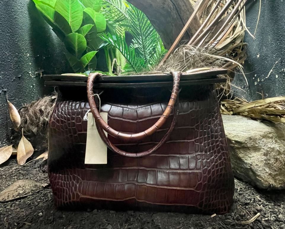 Die Handtasche aus dem Leder eines bedrohten Krokodils in ihrem Gehege im Londoner Zoo.