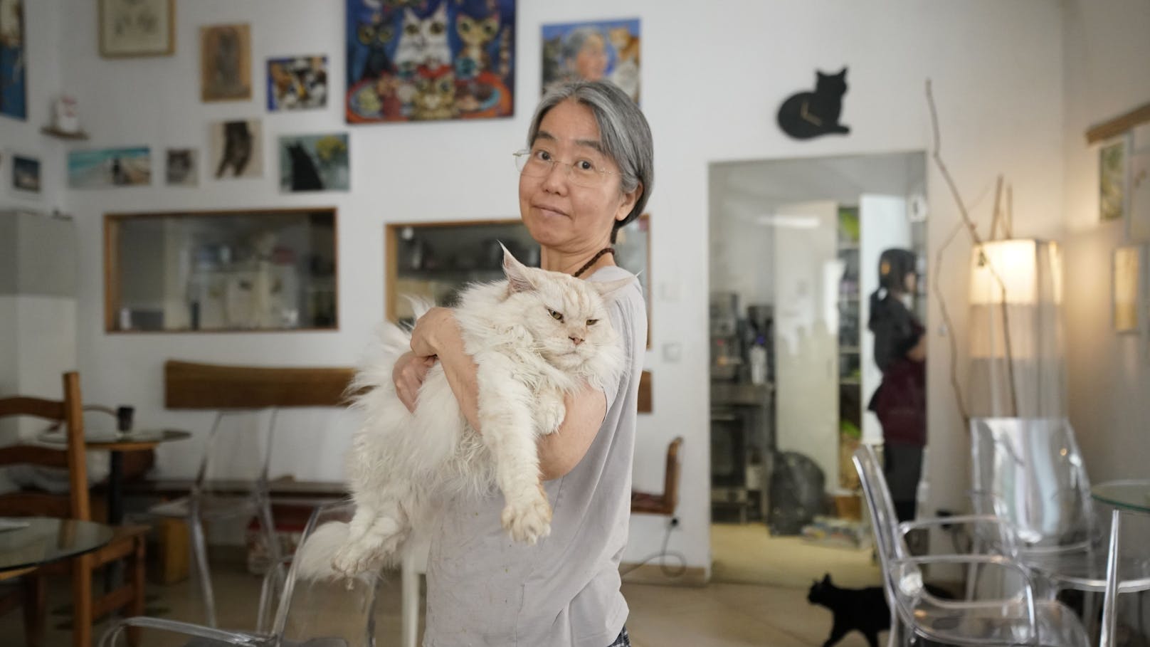 Aus dem Tiefschlaf geholt: Kater Luca (11) mit Frauchen Takako Ishimitsu (58) im Katzencafé Neko