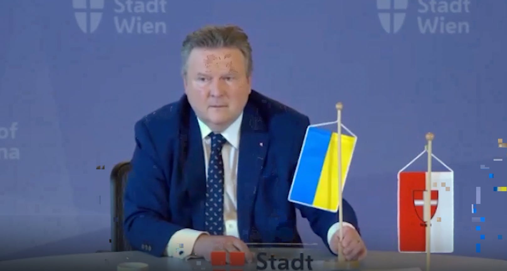 Wiens Stadtchef Ludwig hält die ukrainische Flagge hoch.