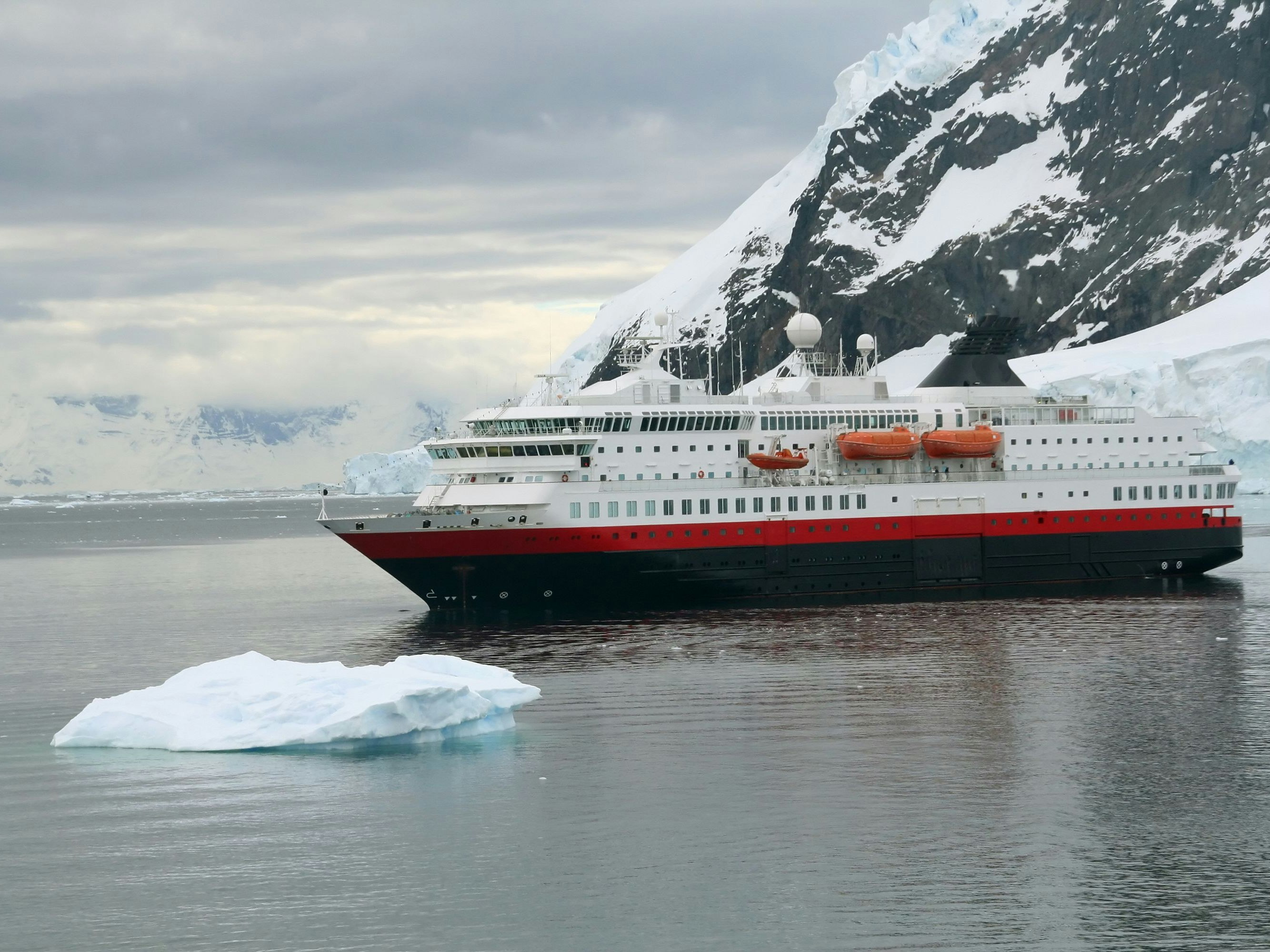 Cruise ship at anchor with glaciers and icebergs,