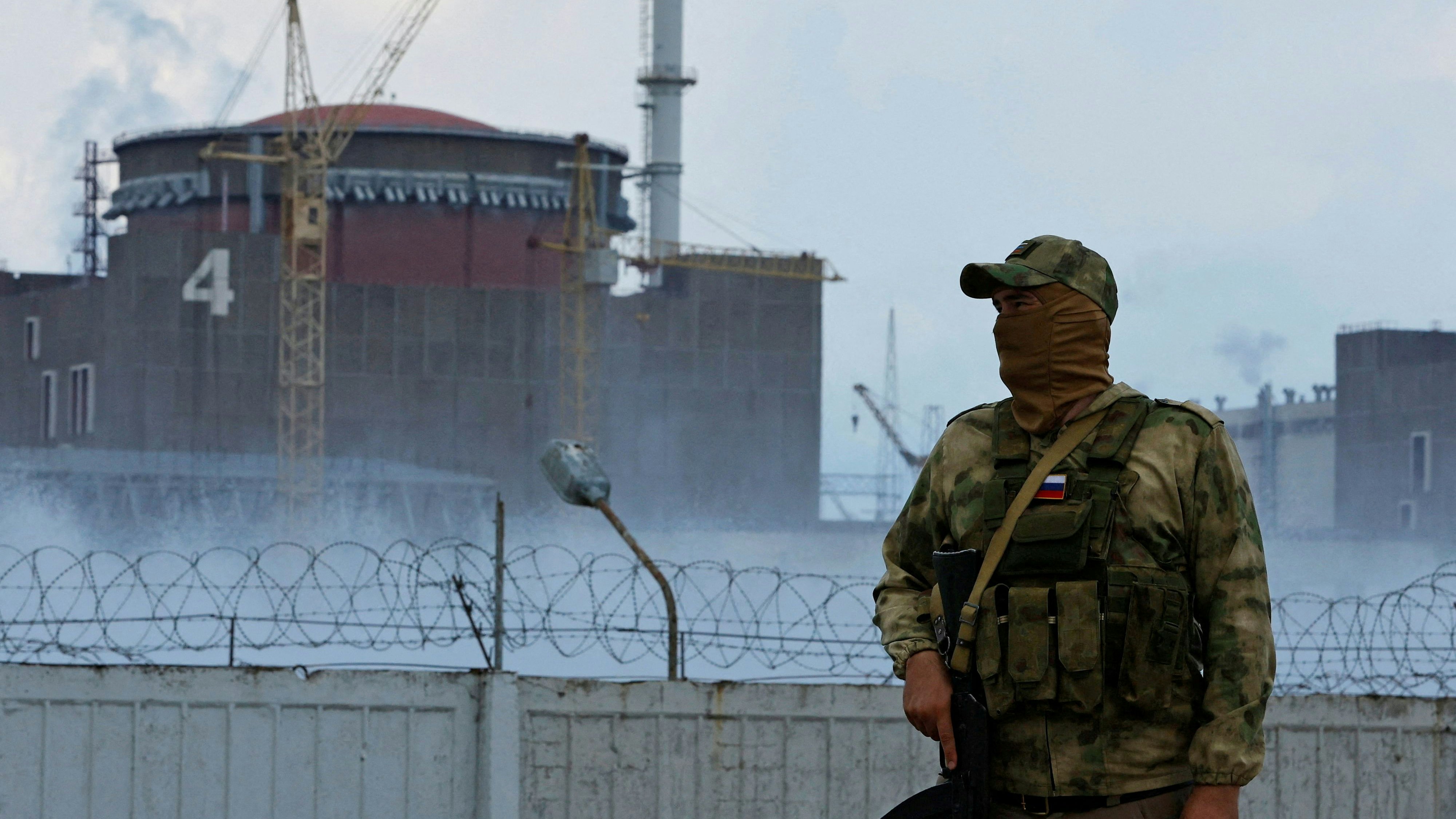 FILE PHOTO: A serviceman with a Russian flag on his uniform stands guard near the Zaporizhzhia Nuclear Power Plant in the course of Ukraine-Russia conflict outside the Russian-controlled city of Enerhodar in the Zaporizhzhia region, Ukraine August 4, 2022. REUTERS/Alexander Ermochenko/File Photo