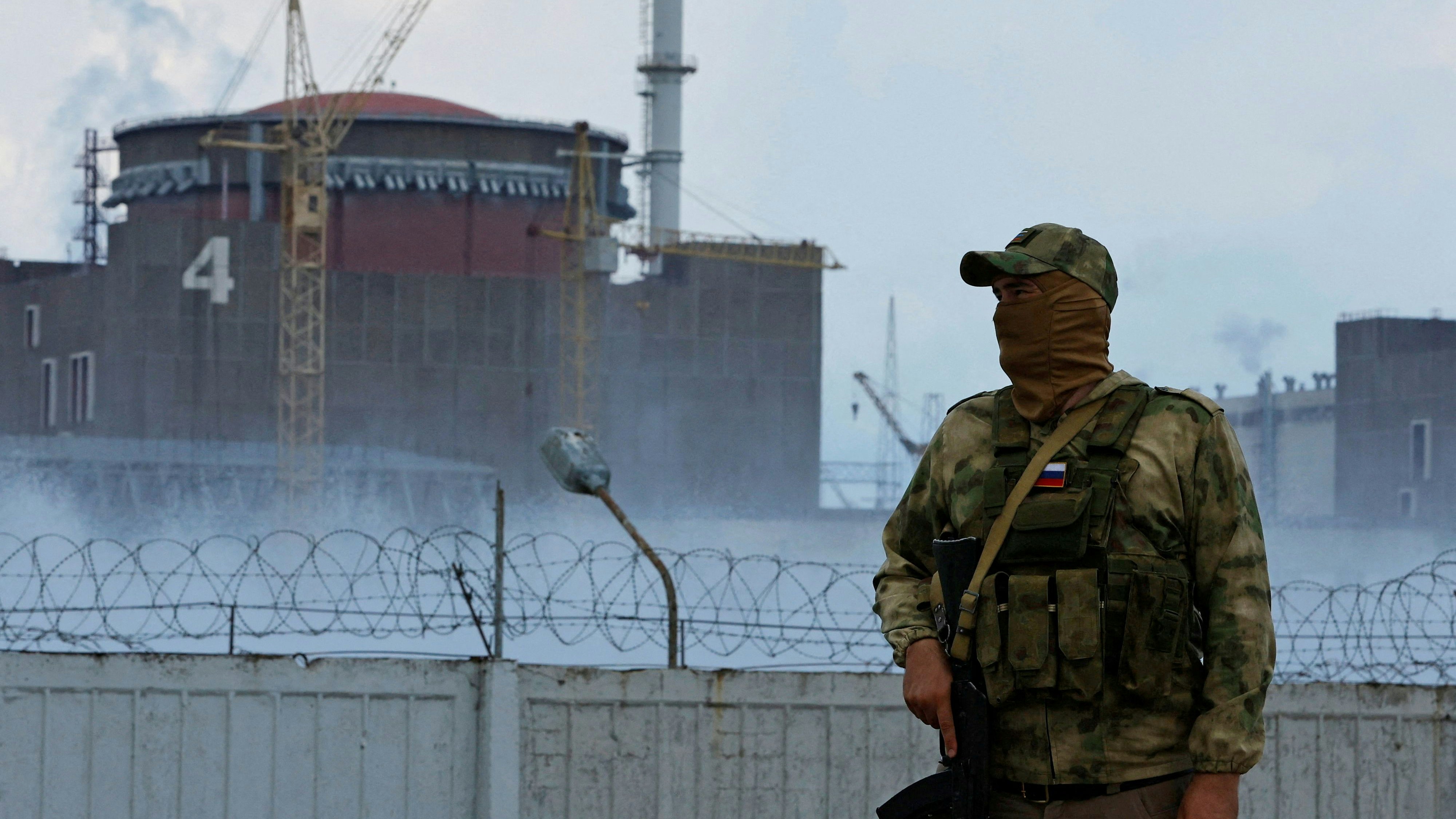 FILE PHOTO: A serviceman with a Russian flag on his uniform stands guard near the Zaporizhzhia Nuclear Power Plant in the course of Ukraine-Russia conflict outside the Russian-controlled city of Enerhodar in the Zaporizhzhia region, Ukraine August 4, 2022. REUTERS/Alexander Ermochenko/File Photo