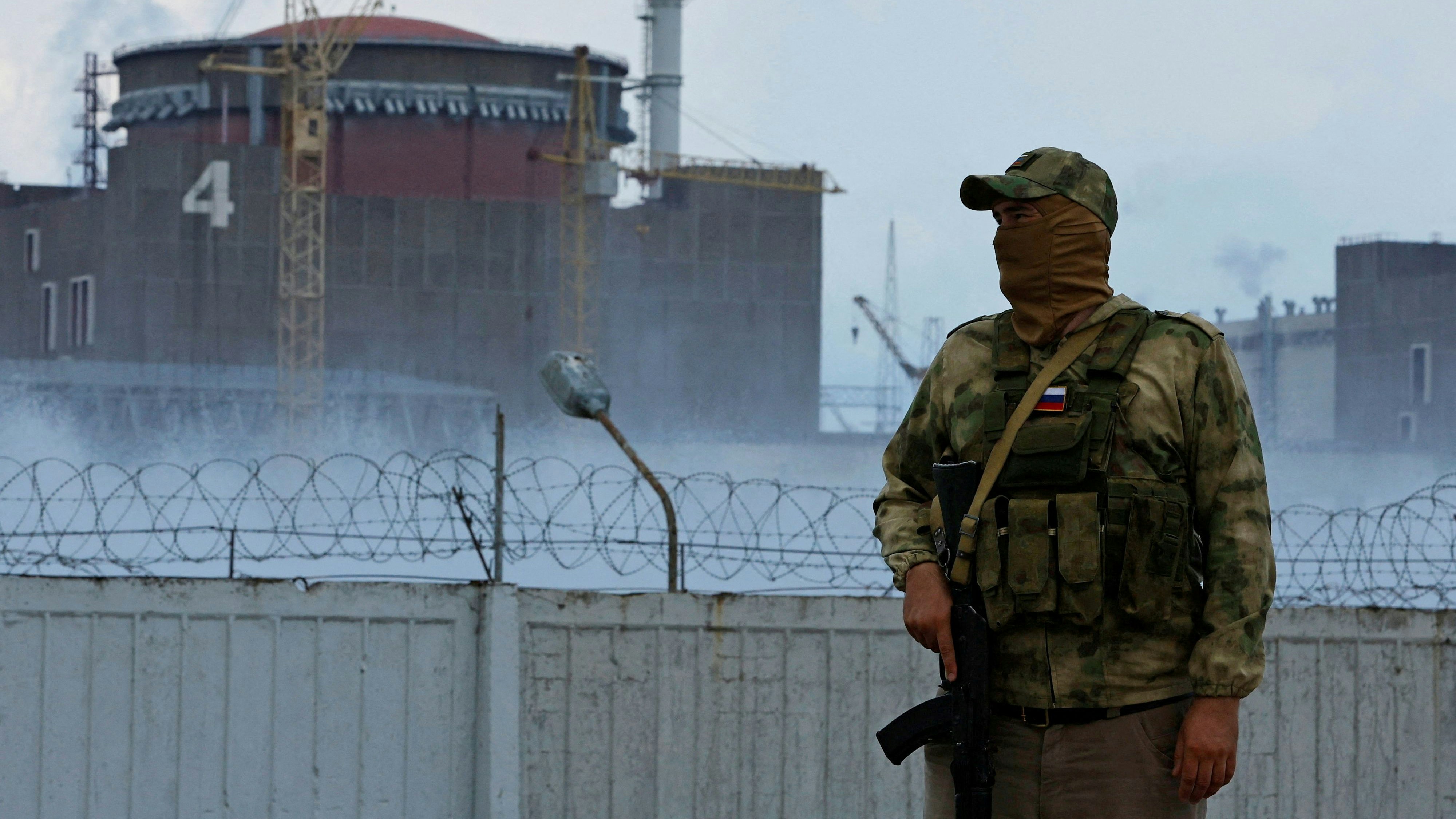 FILE PHOTO: A serviceman with a Russian flag on his uniform stands guard near the Zaporizhzhia Nuclear Power Plant in the course of Ukraine-Russia conflict outside the Russian-controlled city of Enerhodar in the Zaporizhzhia region, Ukraine August 4, 2022. REUTERS/Alexander Ermochenko/File Photo