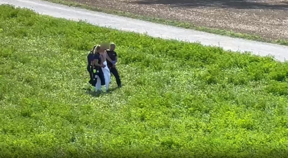 Der Mann saß völlig nackt  und betrunken auf dieser Wiese und 