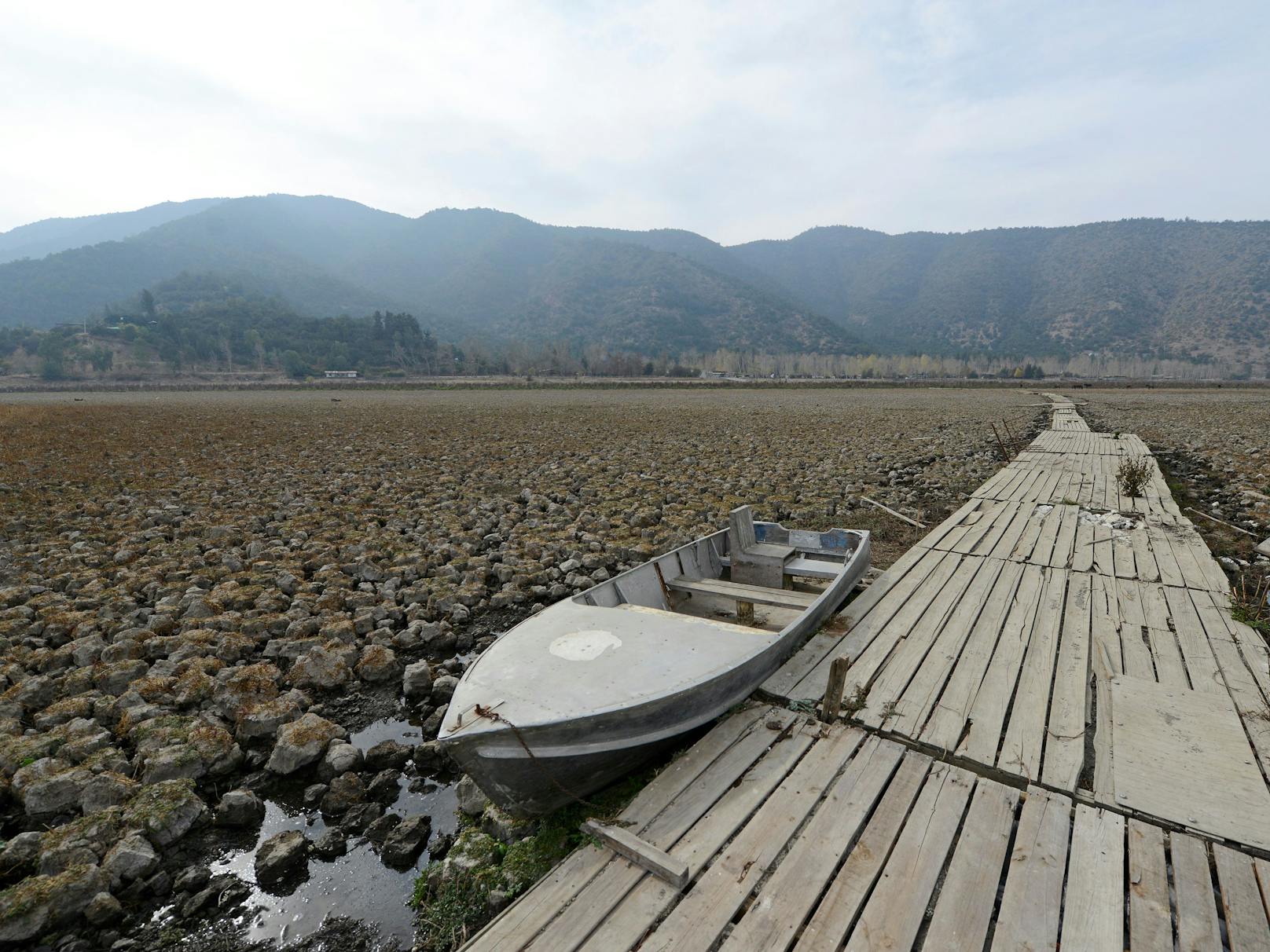 Ein stillgelegter Pier der Aculeo-Lagune in Paine (Chile), der auf trockenem Land steht, das früher mit Wasser gefüllt war.&nbsp;Die Megadürre ist nicht der einzige Grund für den Wassermangel. Chile ist das einzige Land der Welt, in dem sich das Trinkwasser vollständig in Privatbesitz befindet.