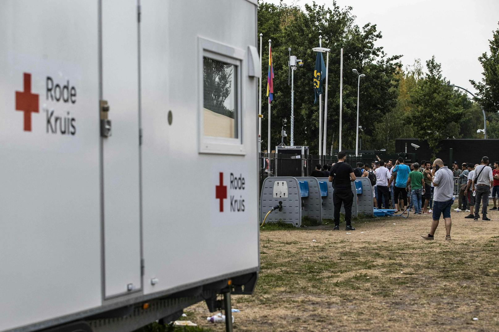 Migranten stehen vor einer vorübergehend geschlossenen humanitären Dienststelle des Roten Kreuzes in der Nähe des Eingangs des Antragszentrums für Asylbewerber aufgrund der Unruhen am vergangenen Wochenende an den Toren in Ter Apel am 15. August 2022.