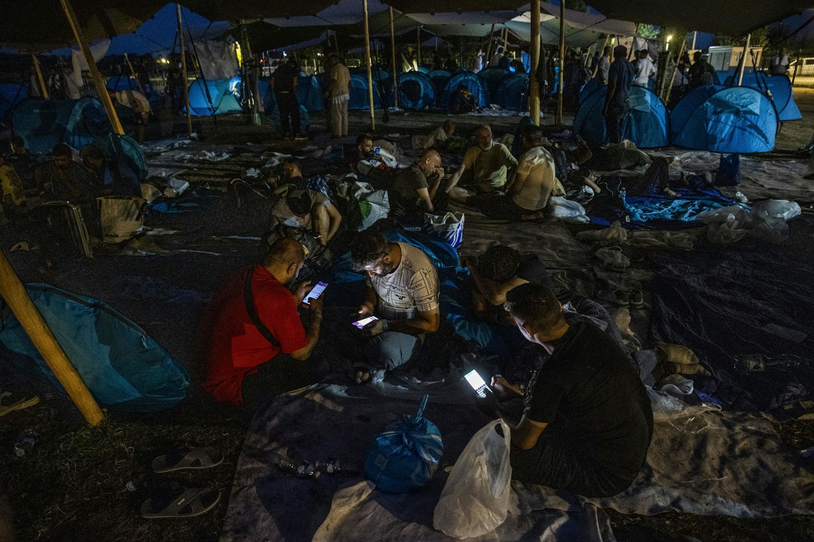 15.08.22: Asylbewerber bereiten ihre provisorische Unterkunft für die Nacht vor.