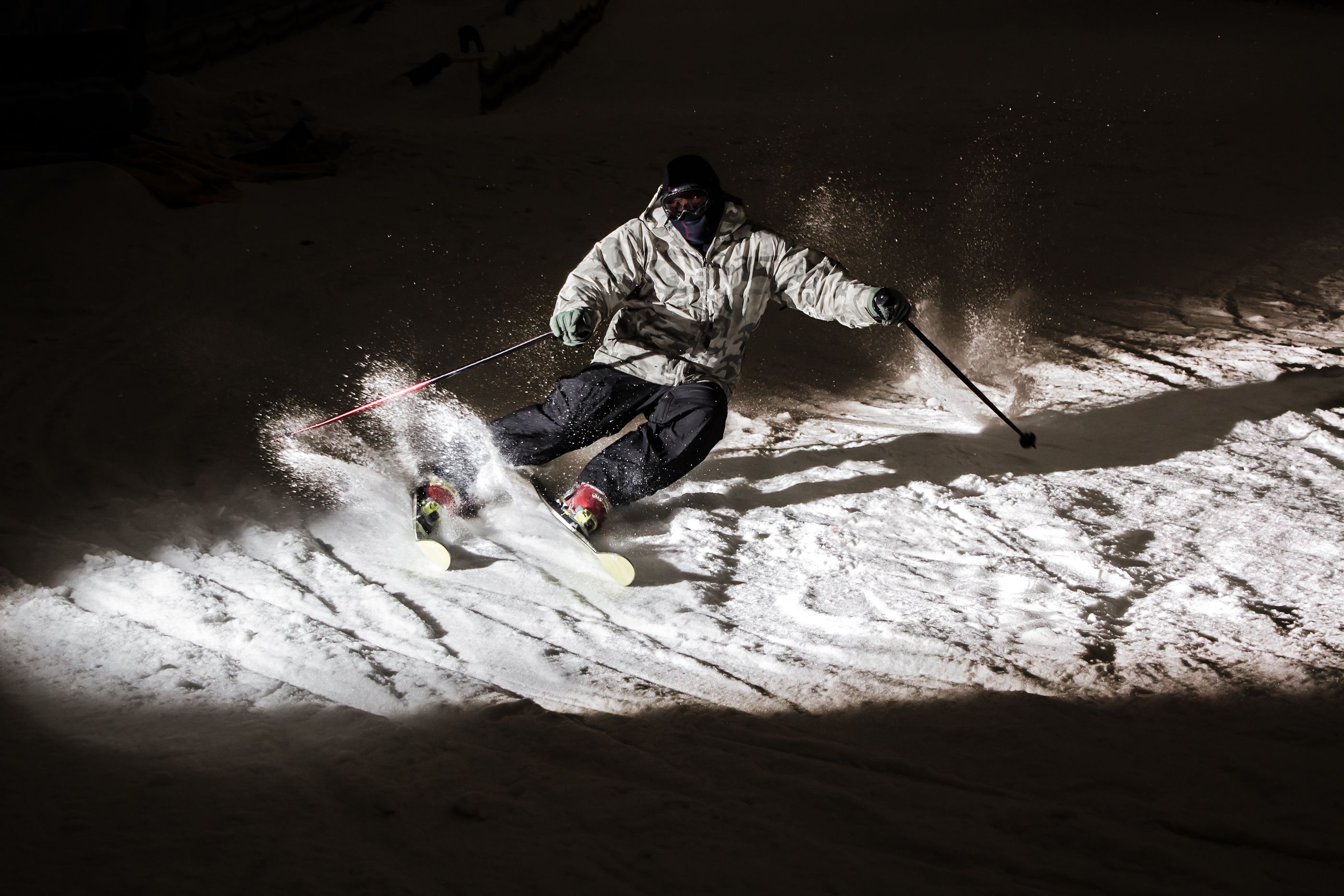 Skiing in the dark in a closed snow park, highlighted flash