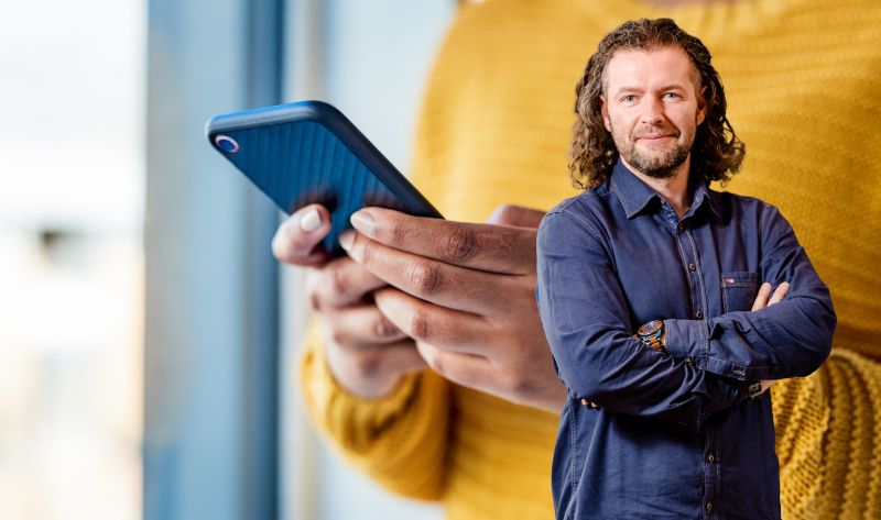 Firmenchef Paul Dyrek und Symbolfoto einer Frau mit Handy.